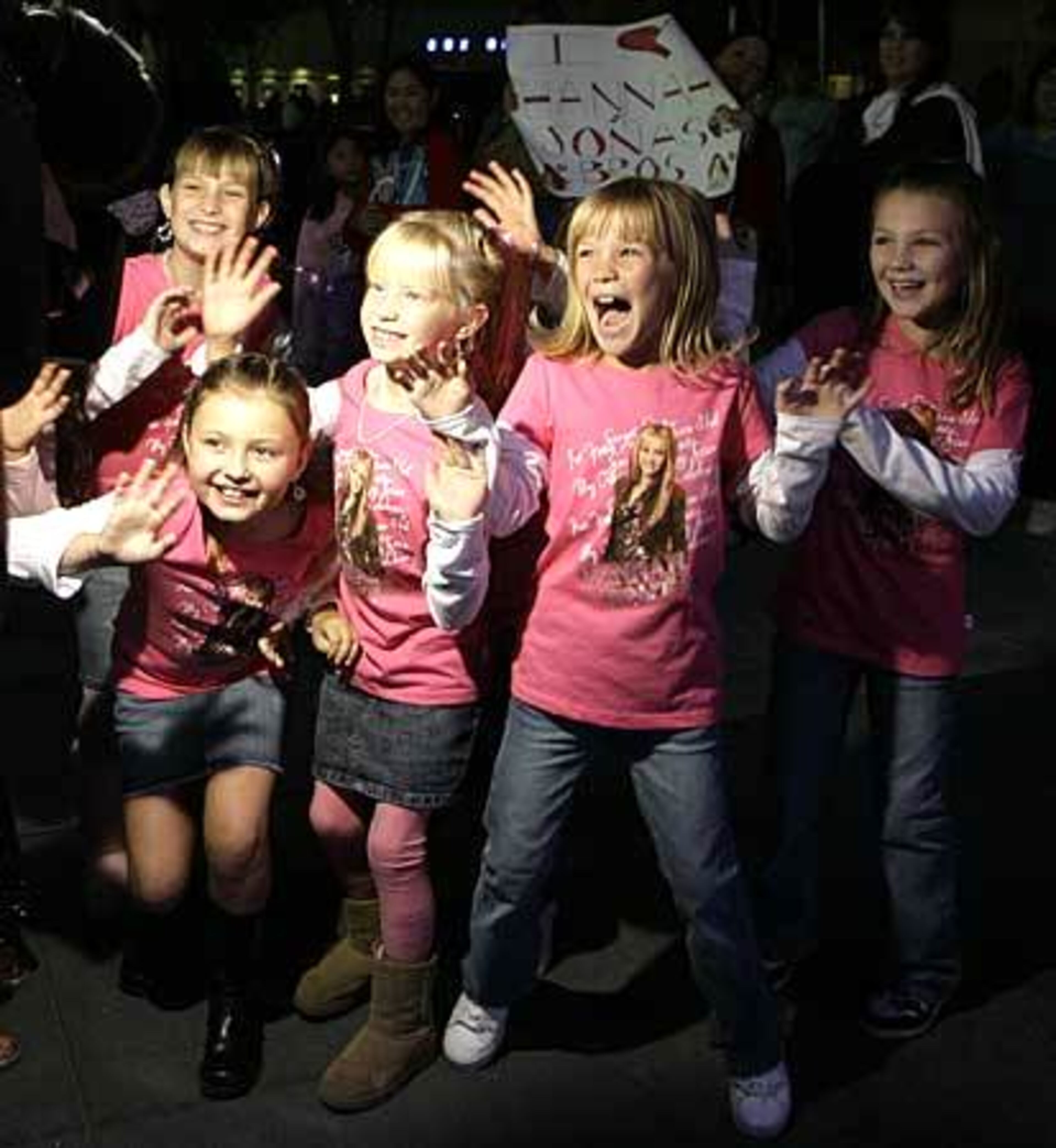 Young fans of Miley Cyrus wave to a television news cameras as they participate in the Ultimate Miley Party Bus Tour 2007.