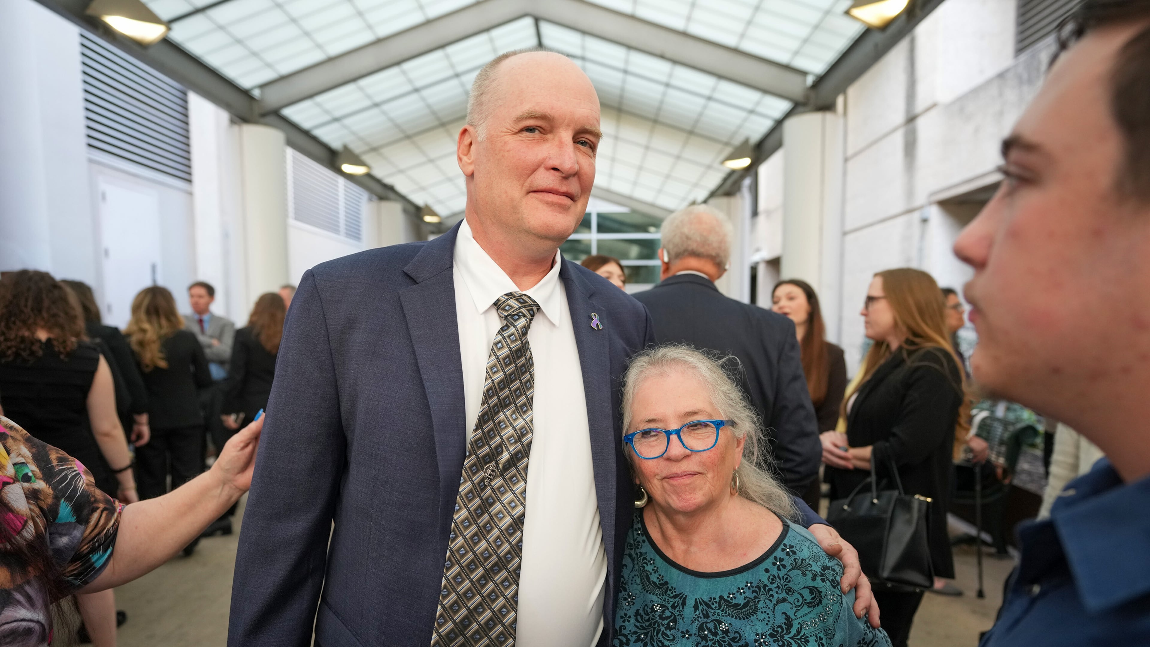 FILE - Michael Scott, left, hugs Sharon Shipman, the mother of yogurt shop suspect Forrest Welborn, after he was exonerated at a hearing for four men wrongfully accused in the 1991 Austin yogurt shop murders at the Blackwell-Thurman Criminal Justice Center in Austin, Texas, Feb. 19, 2026. (Jay Janner/Austin American-Statesman via AP, File)
