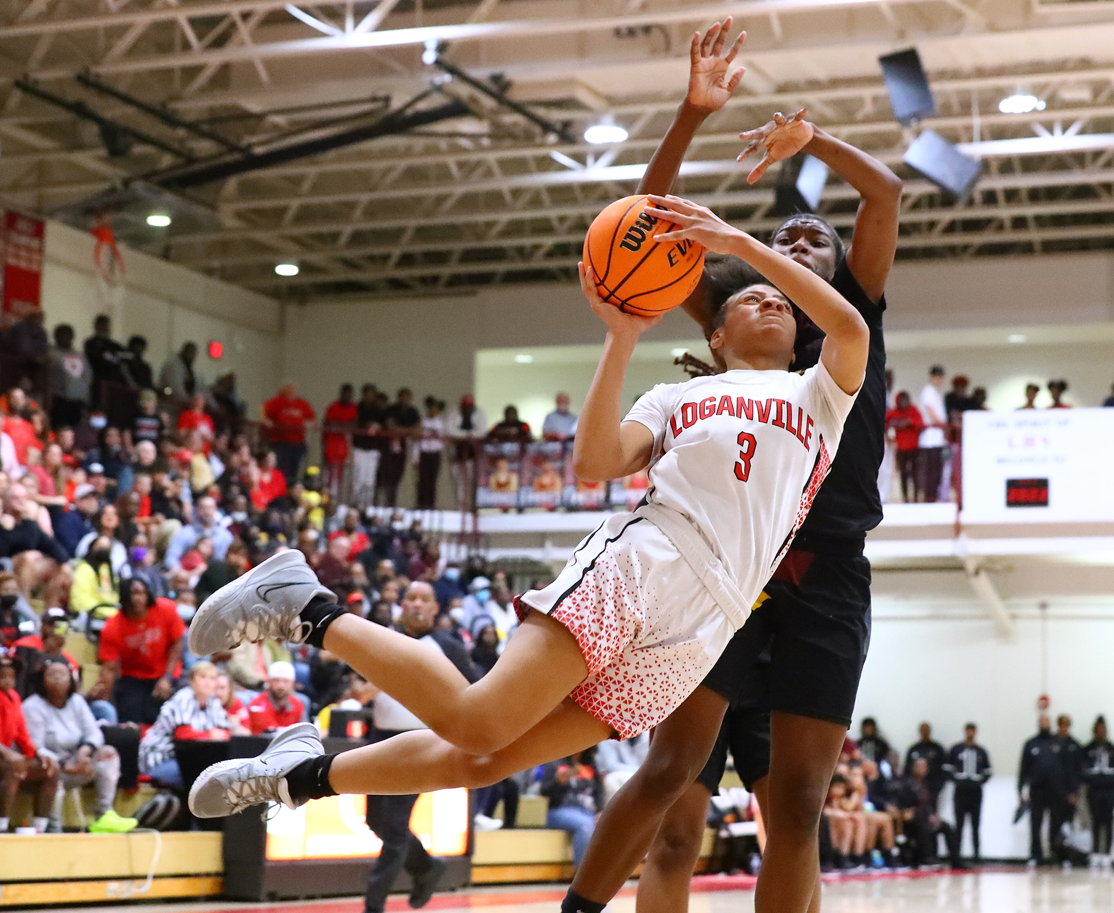 Loganville guard Sydney Bolden soars to the basket against Forest Park forward Janiya Simmons in their high school basketball tournament game on Wednesday, March 2, 2022, in Loganville. “Curtis Compton / Curtis.Compton@ajc.com”`