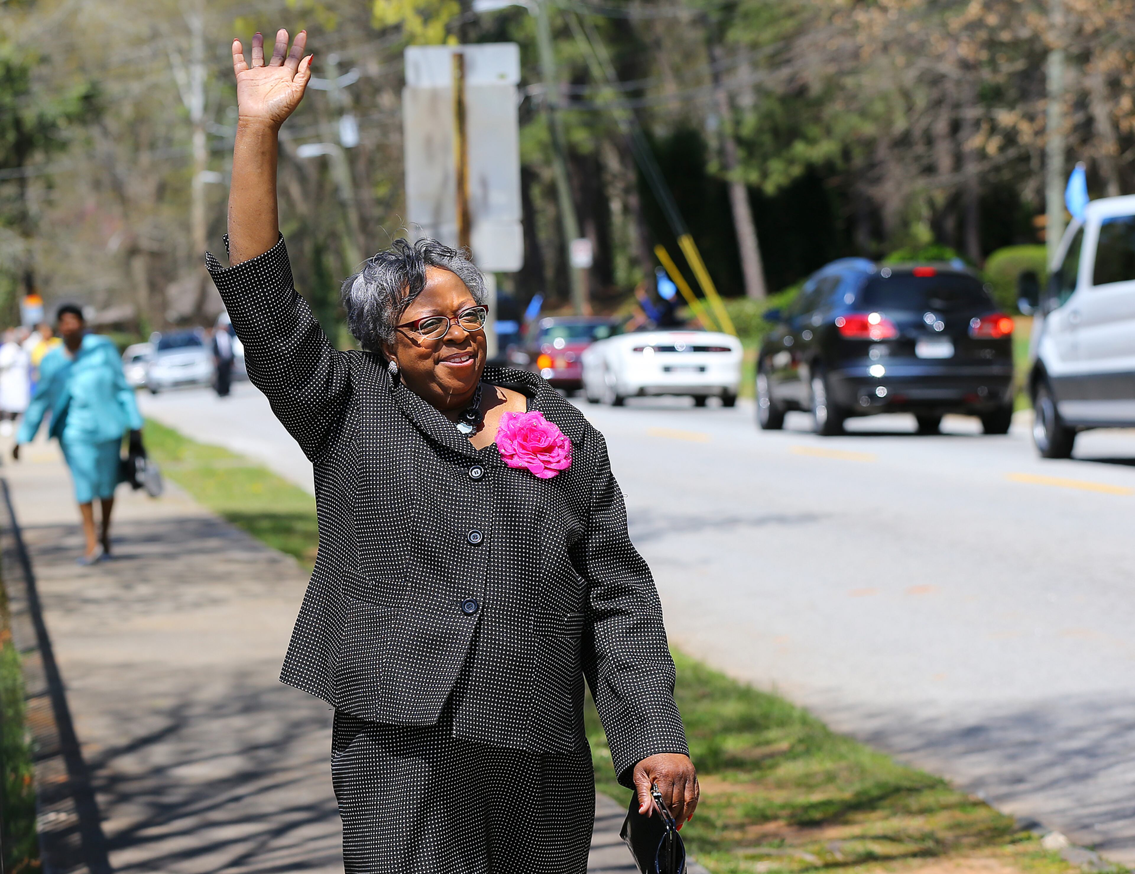 Visitor Pat Ellis waves at the parade of cars full of church members as she arrivers for the Entrance Service at Mount Vernon Baptist Church on Palm Sunday, March 29, 2015, in Atlanta. The church moved locations to make way for the Falcons new stadium. Curtis Compton / ccompton@ajc.com