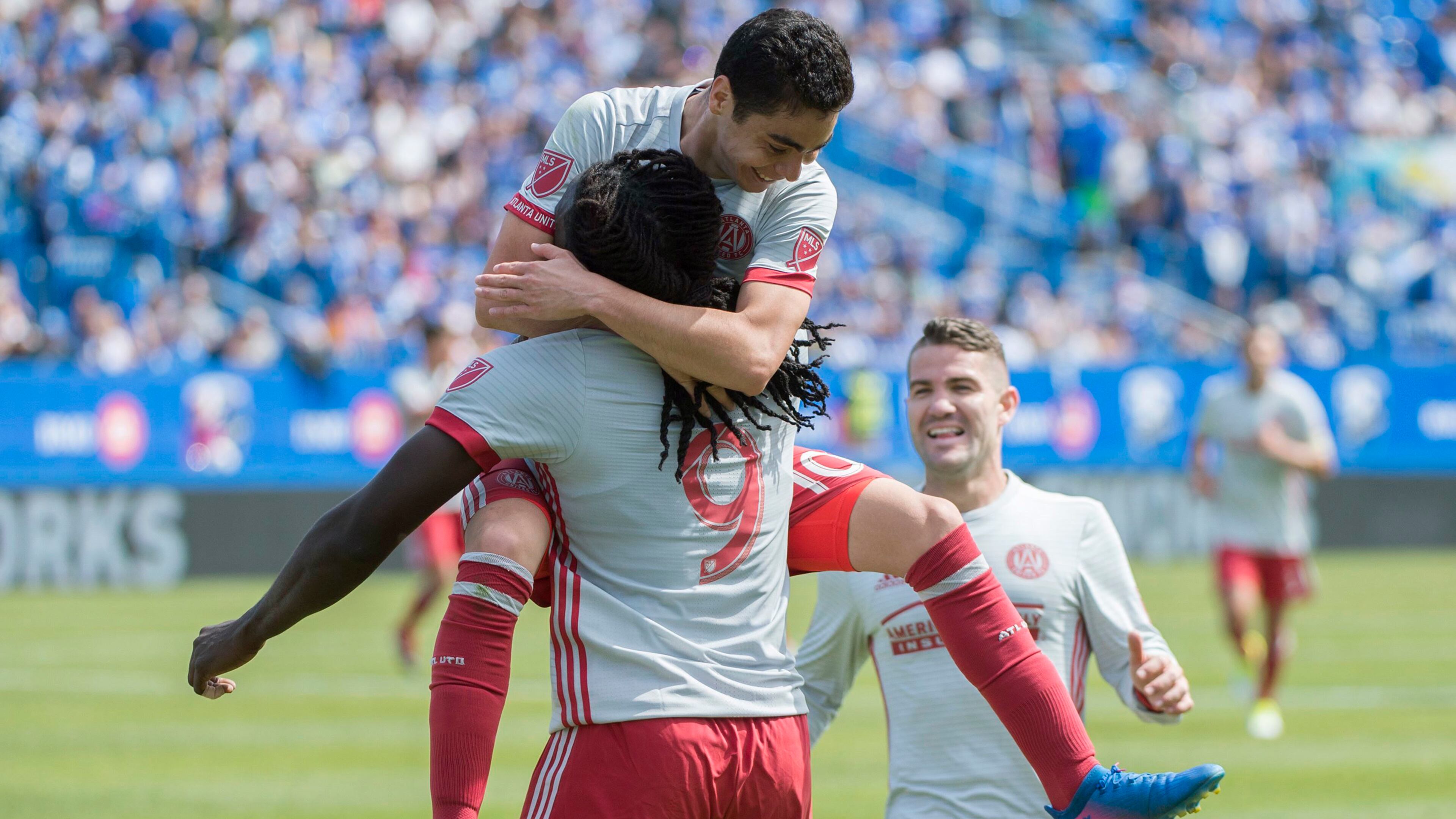 Atlanta United’s Kenwyne Jones (9) celebrates with teammates Miguel Almiron (10) and Greg Garza (4) after scoring during the first half of an MLS soccer game against the Montreal Impact, in Montreal, Saturday, April 15, 2017. (Graham Hughes/The Canadian Press via AP)