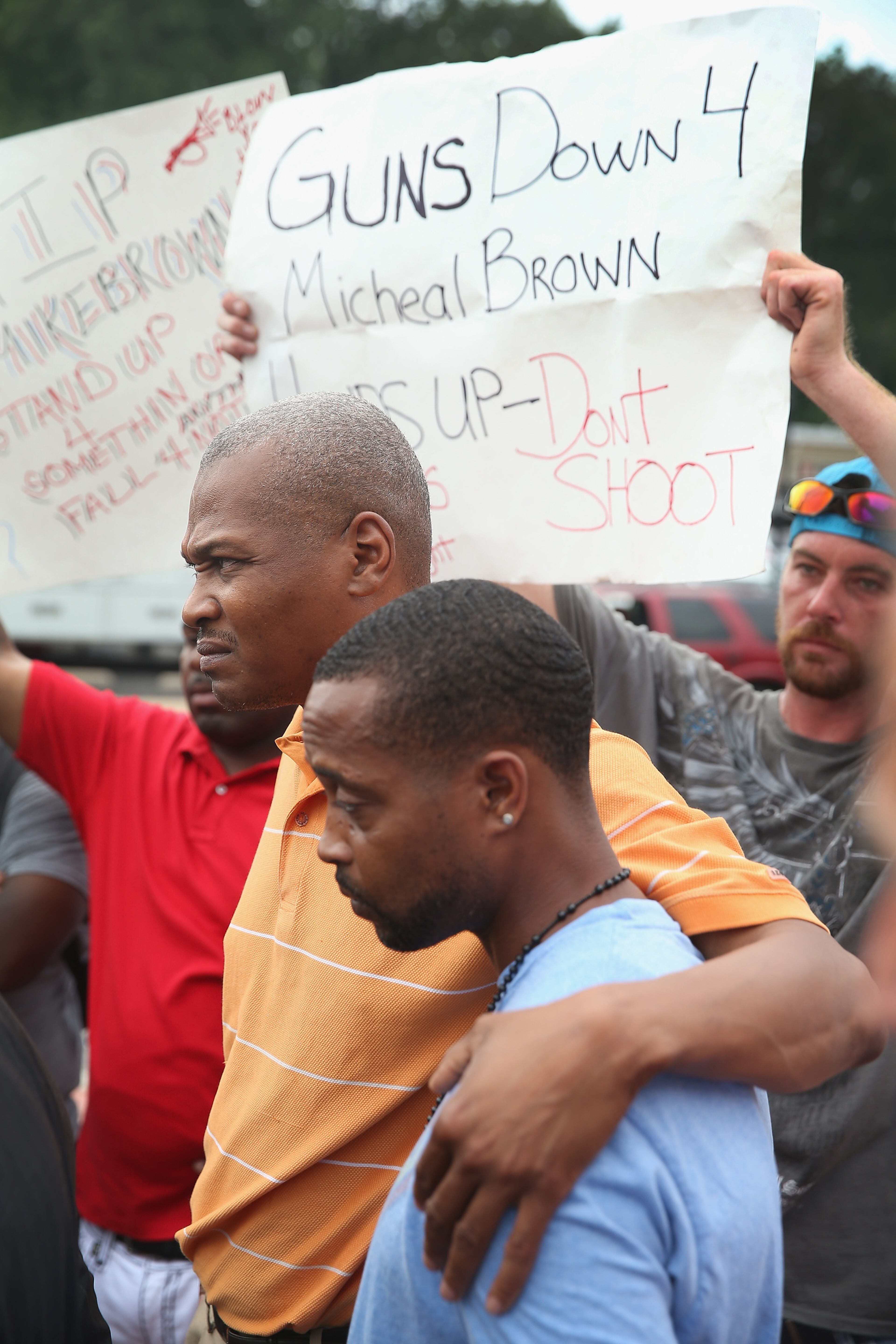 FERGUSON, MO - AUGUST 15: Eric Davis (L), the cousin of Michael Brown, comforts Louis Head, Brown's stepfather, during a press conference outside the police department on August 15, 2014 in Ferguson, Missouri. Brown was shot and killed by a Ferguson police officer on August 9. The killing sparked several days of violent protests in the city. (Photo by Scott Olson/Getty Images)