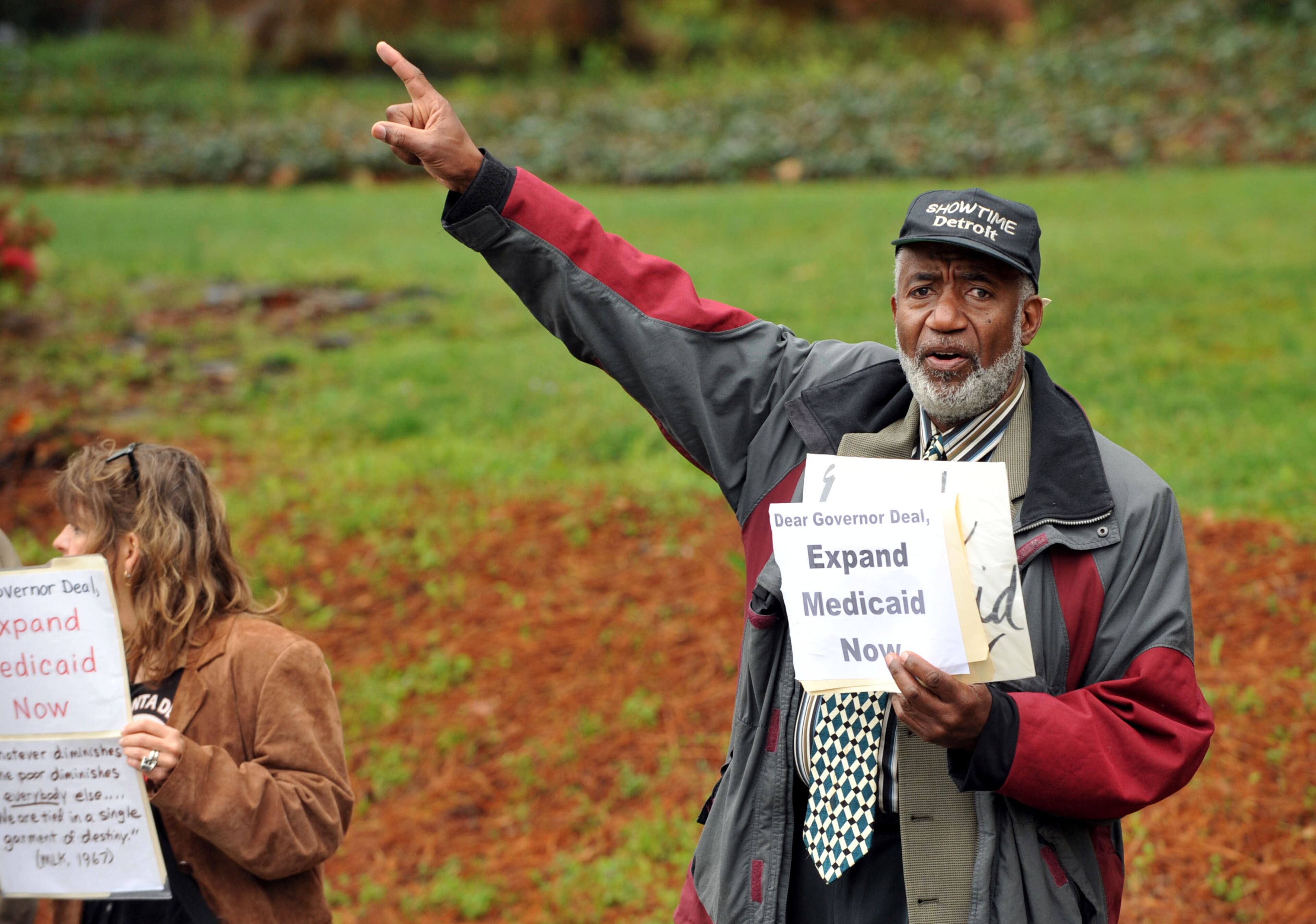Ron Shakir of Atlanta pumps up passing motorists and protesters. About 75 protesters including several Atlanta clergy members and officials joined with Moral Monday in a Medicaid expansion protest outside the Governor's Mansion on W. Paces Ferry Road Monday, April 7, 2014. Protesters were calling on Governor Nathan Deal to expand Medicaid services in the state. KENT D. JOHNSON / KDJOHNSON@AJC.COM