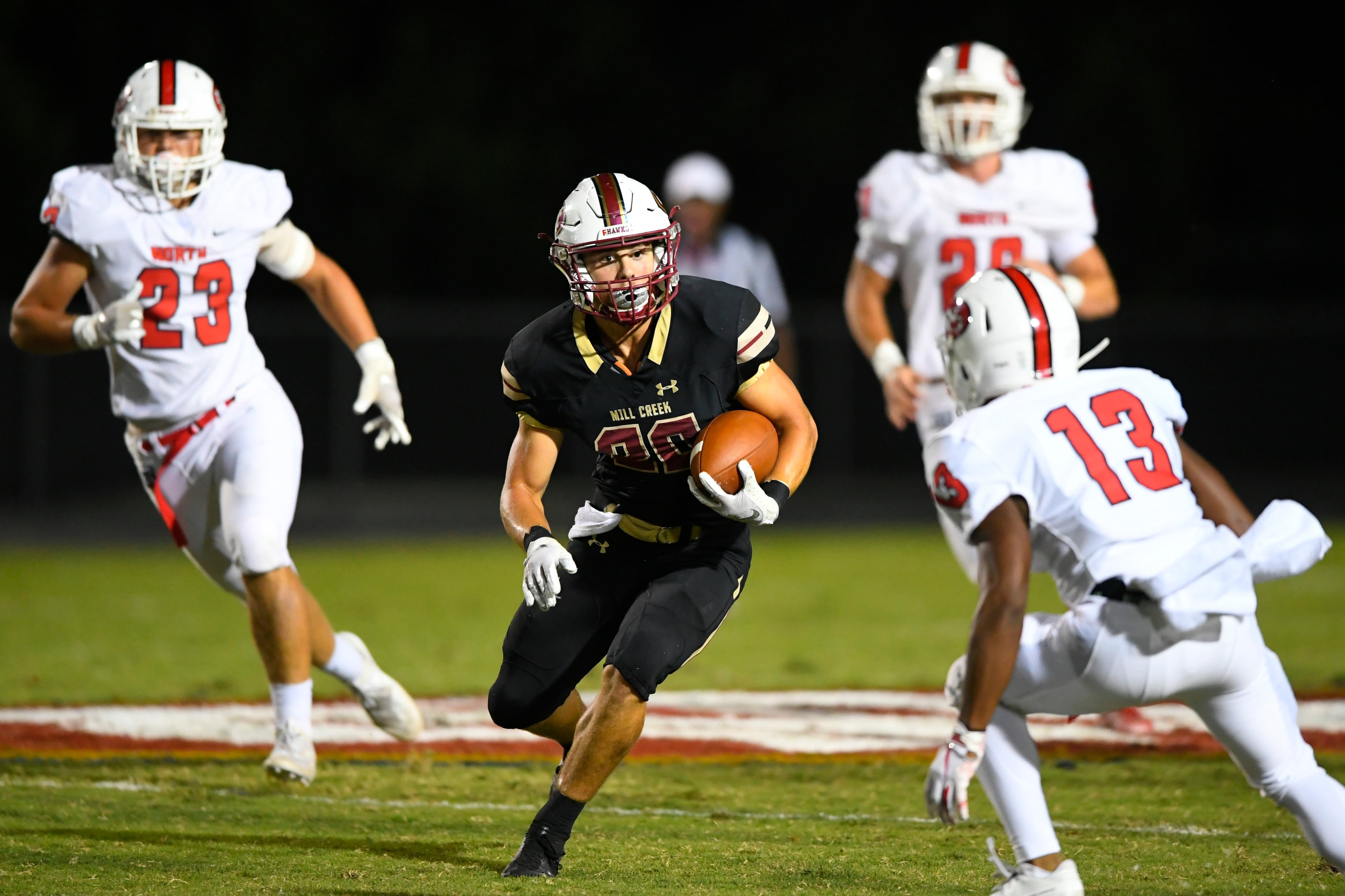 Mill Creek's Parker Wroble rushes against the defense of North Gwinnett's Jarvis Cunningham (13) Hayden Morton (23) and Cole Moore during Friday's game in Hoschton. (John Amis/Special)