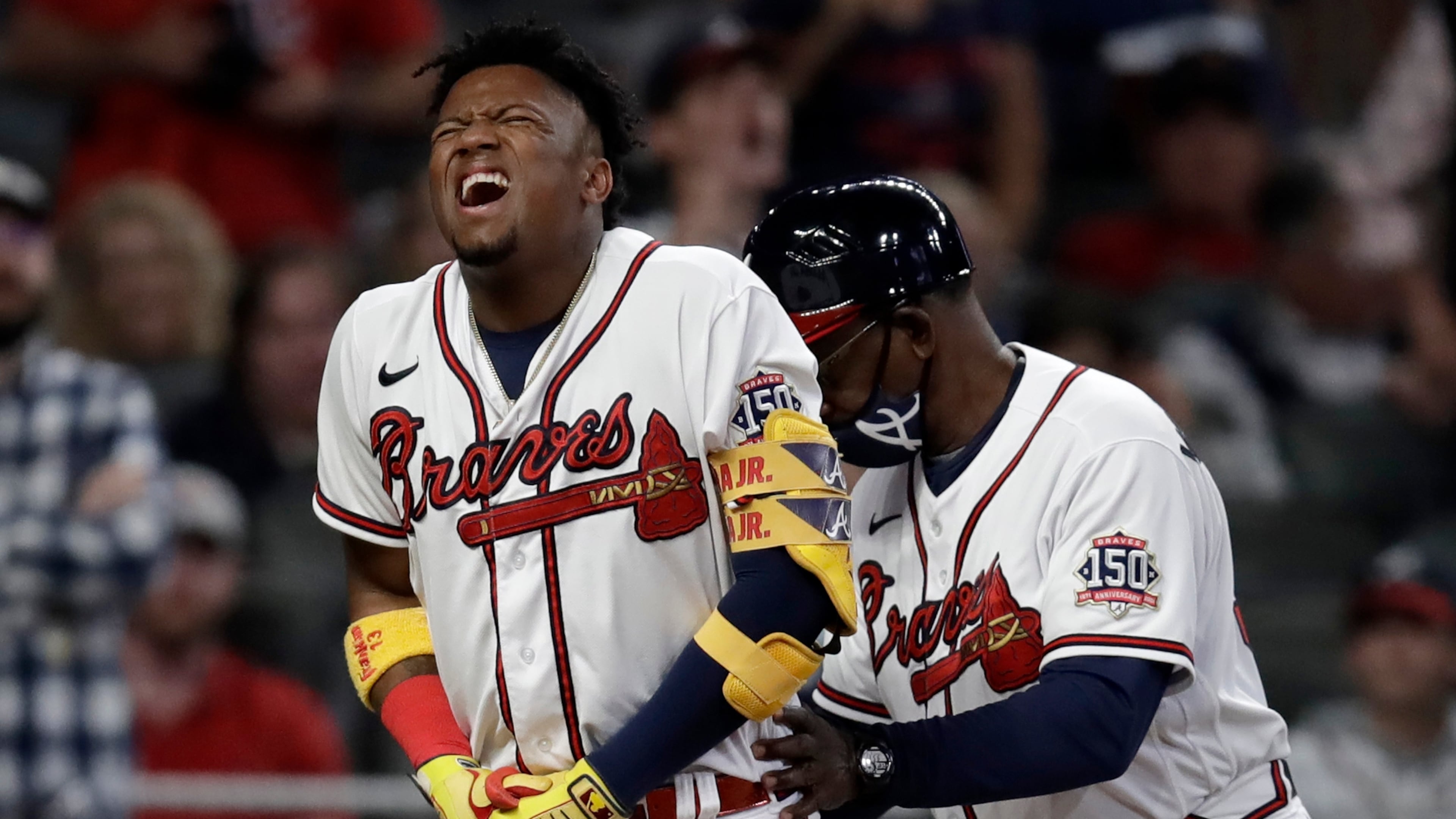 Atlanta Braves' Ronald Acuna Jr., left, is assisted by third base coach Ron Washington after being hit by a pitch thrown by Philadelphia Phillies' Sam Coonrod in the seventh inning of a baseball game Saturday, May 8, 2021, in Atlanta. (AP Photo/Ben Margot)