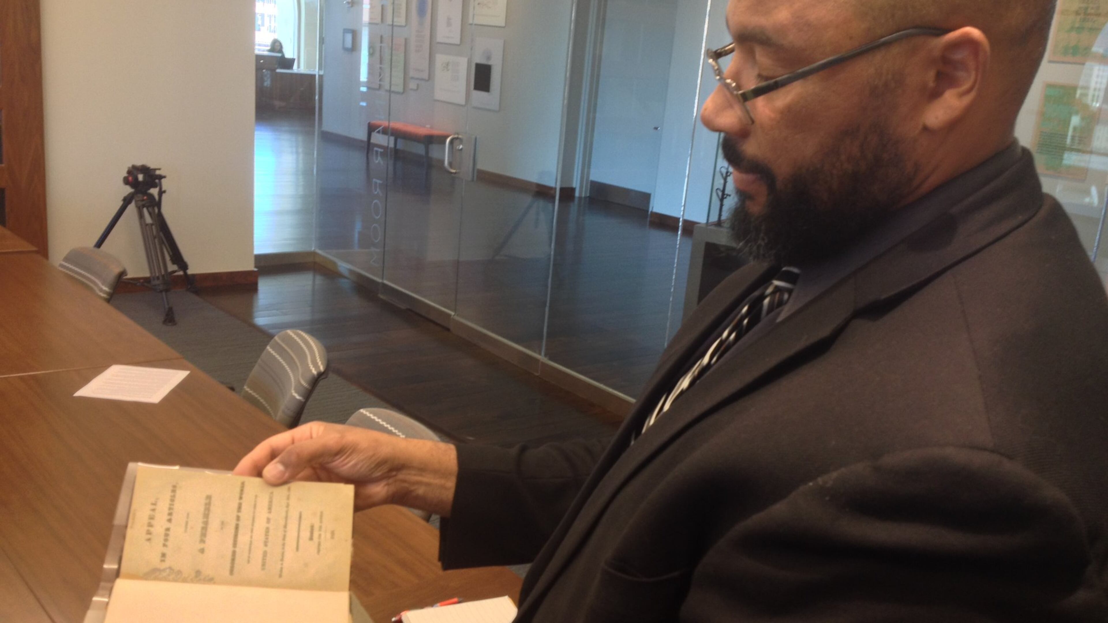 Pellom McDaniels III, a faculty curator of the African American Collections at Emory, marvels at a rare copy of “David Walker’s Appeal” in this AJC file photo. McDaniels died Sunday, April 19, 2020. He was 52.