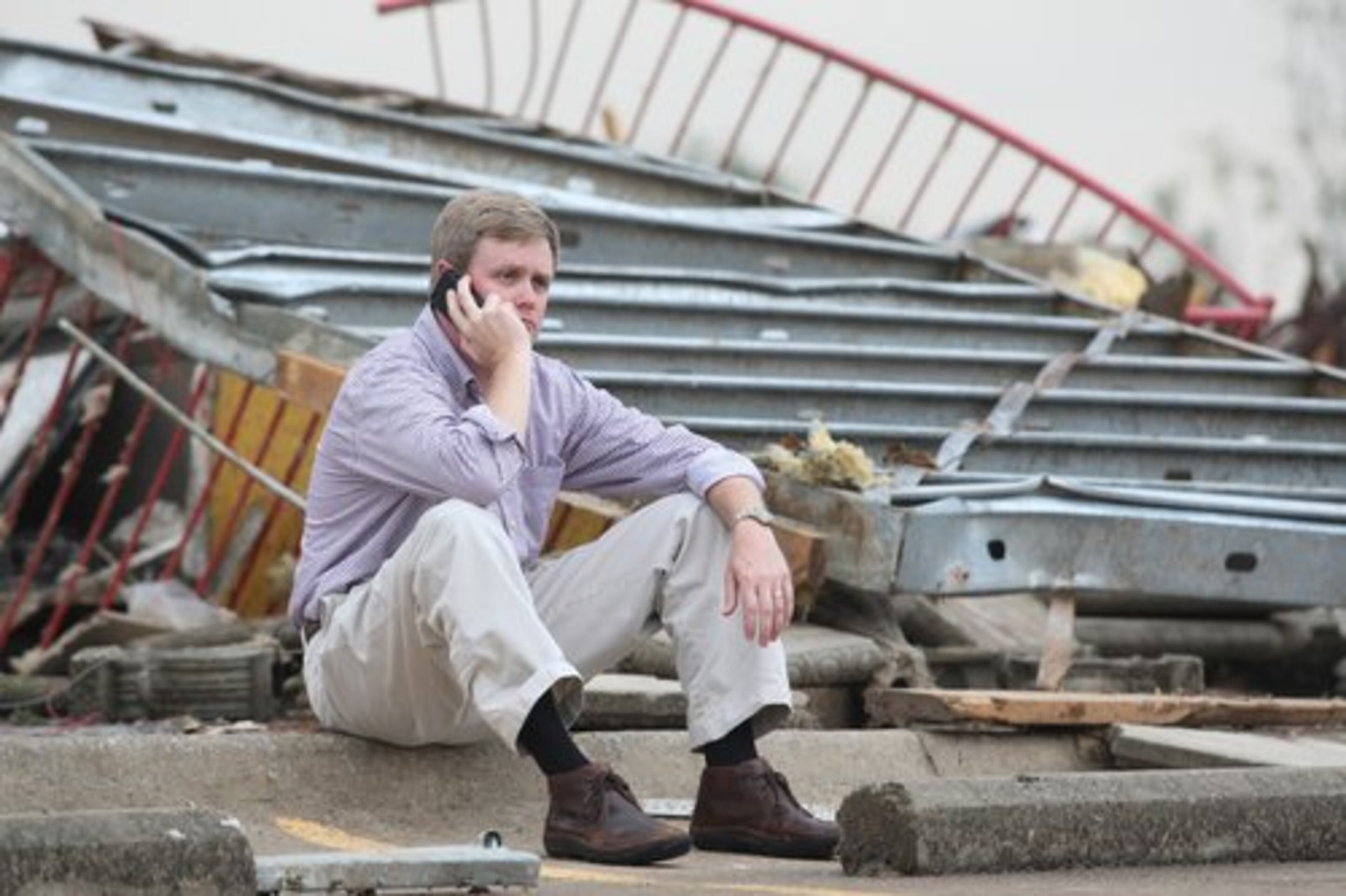Lee Henderson sits amid the rubble of his Smoothie King store in Tuscaloosa, Ala.
