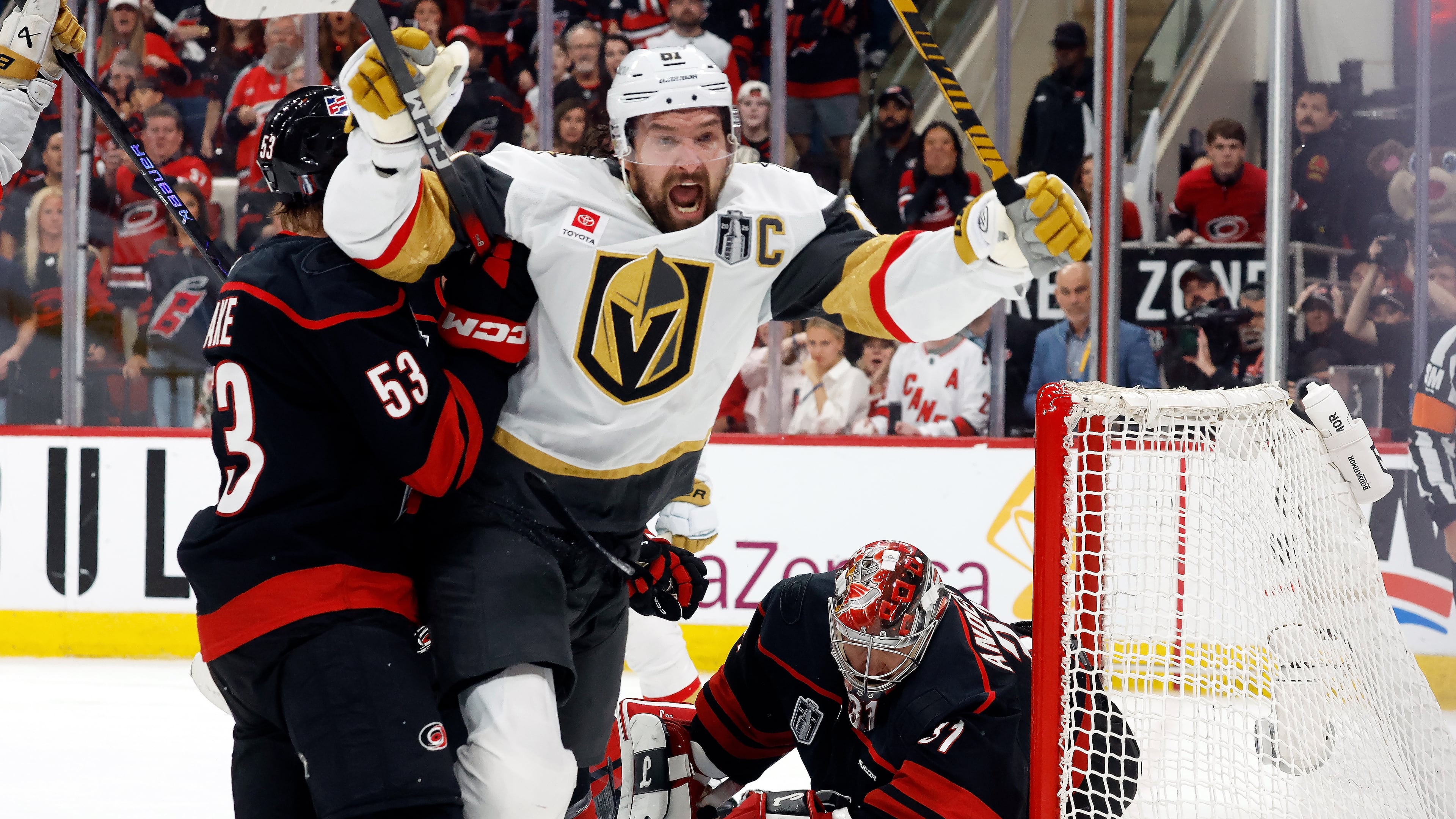 Vegas Golden Knights' Mark Stone (61) celebrates after his goal while in the grasp of Carolina Hurricanes' Jackson Blake (53) with Hurricanes goaltender Frederik Andersen, right, nearby during the third period in Game 2 of the NHL hockey Stanley Cup Final series in Raleigh, N.C., Thursday, June 4, 2026. (AP Photo/Karl DeBlaker)
