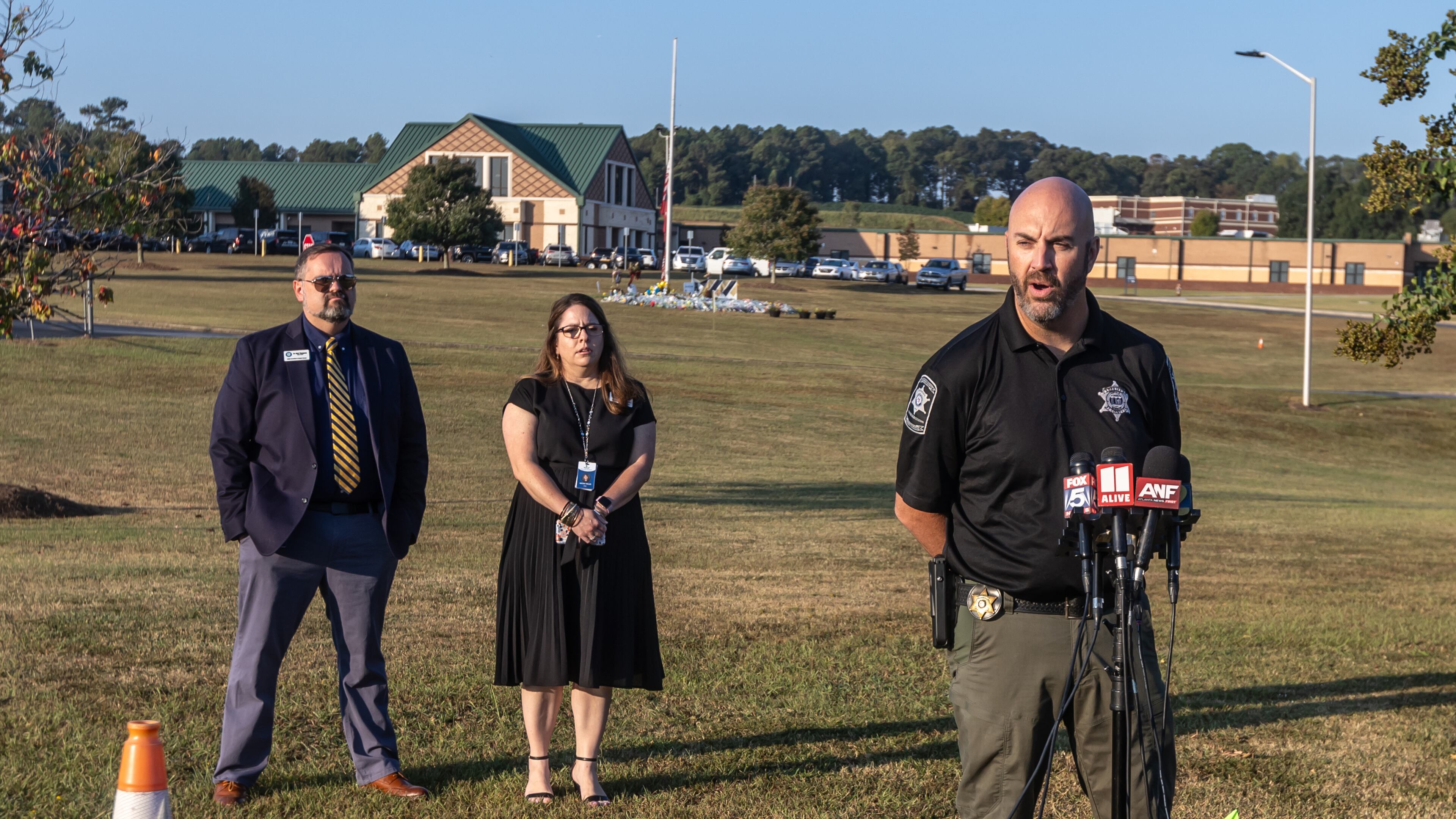 Barrow County Sheriff Jud Smith (right) speaks as Barrow County Schools Chief of Staff Matt Thompson (left) and Director of Communications and Engagement Nicole Valles (center) look on. Months after a student is accused of shooting and killing four people at Apalachee High School, the county is struggling to hire new school resource officers. (John Spink/AJC 2024)