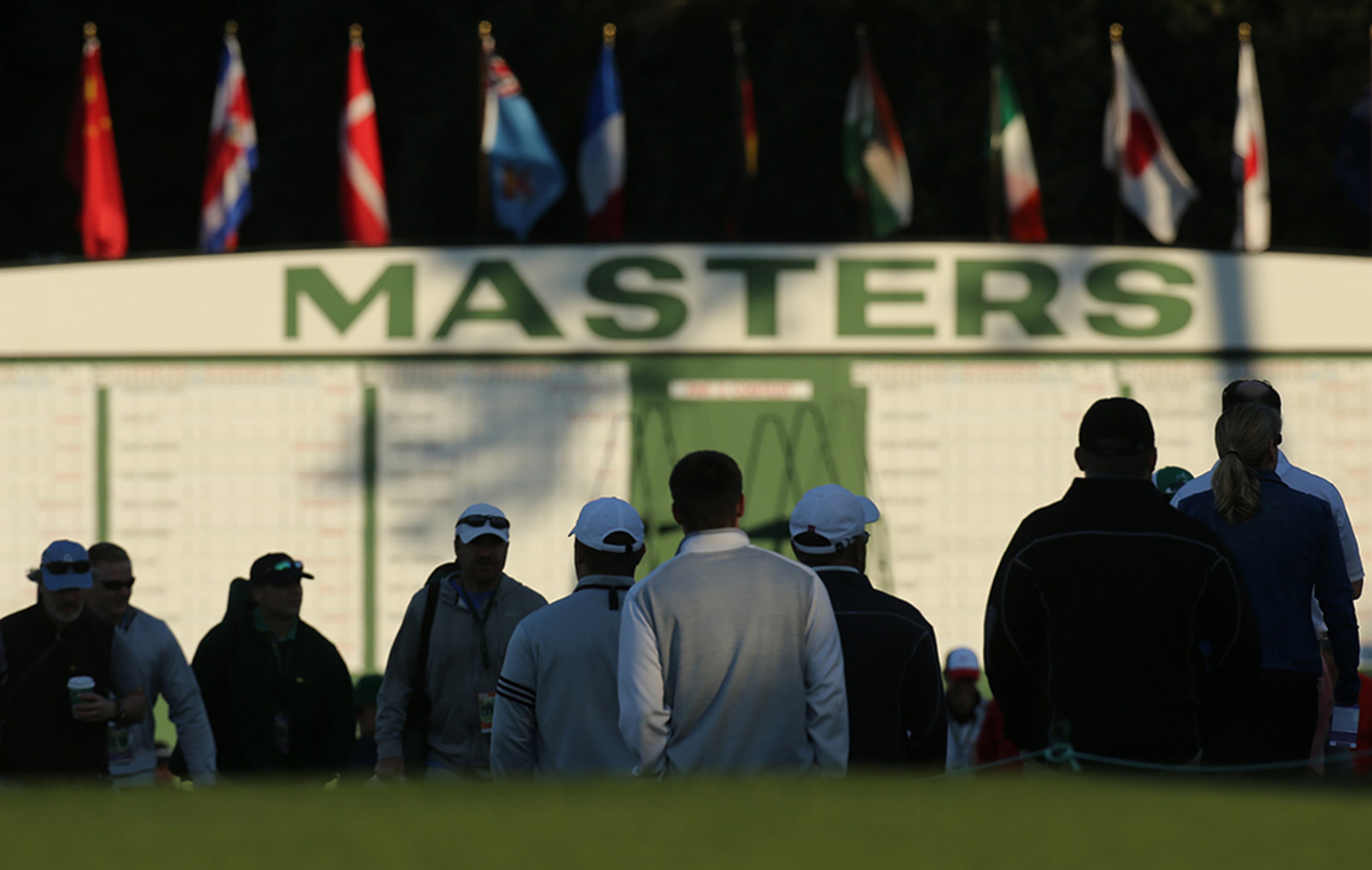 Golf patrons make their way along the first fairway past the Masters scoreboard when the gates to the course open at Augusta National Golf Club on Wednesday, April 6, 2016, in Augusta.