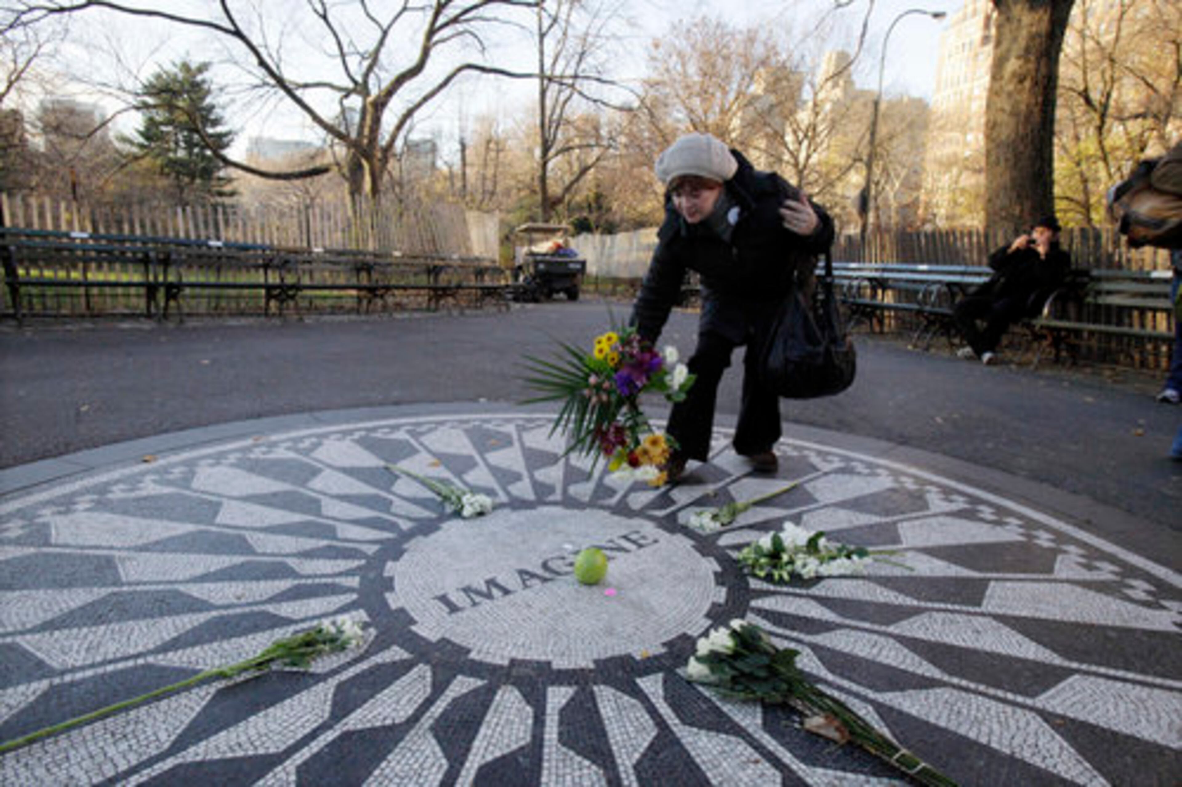 IMAGINE--Robin Grinholz, of New York, lays flowers on the Imagine mosaic in the Strawberry Fields section of New York's Central Park, Wednesday, Dec. 8, 2010, the 30th anniversary of the death of John Lennon.