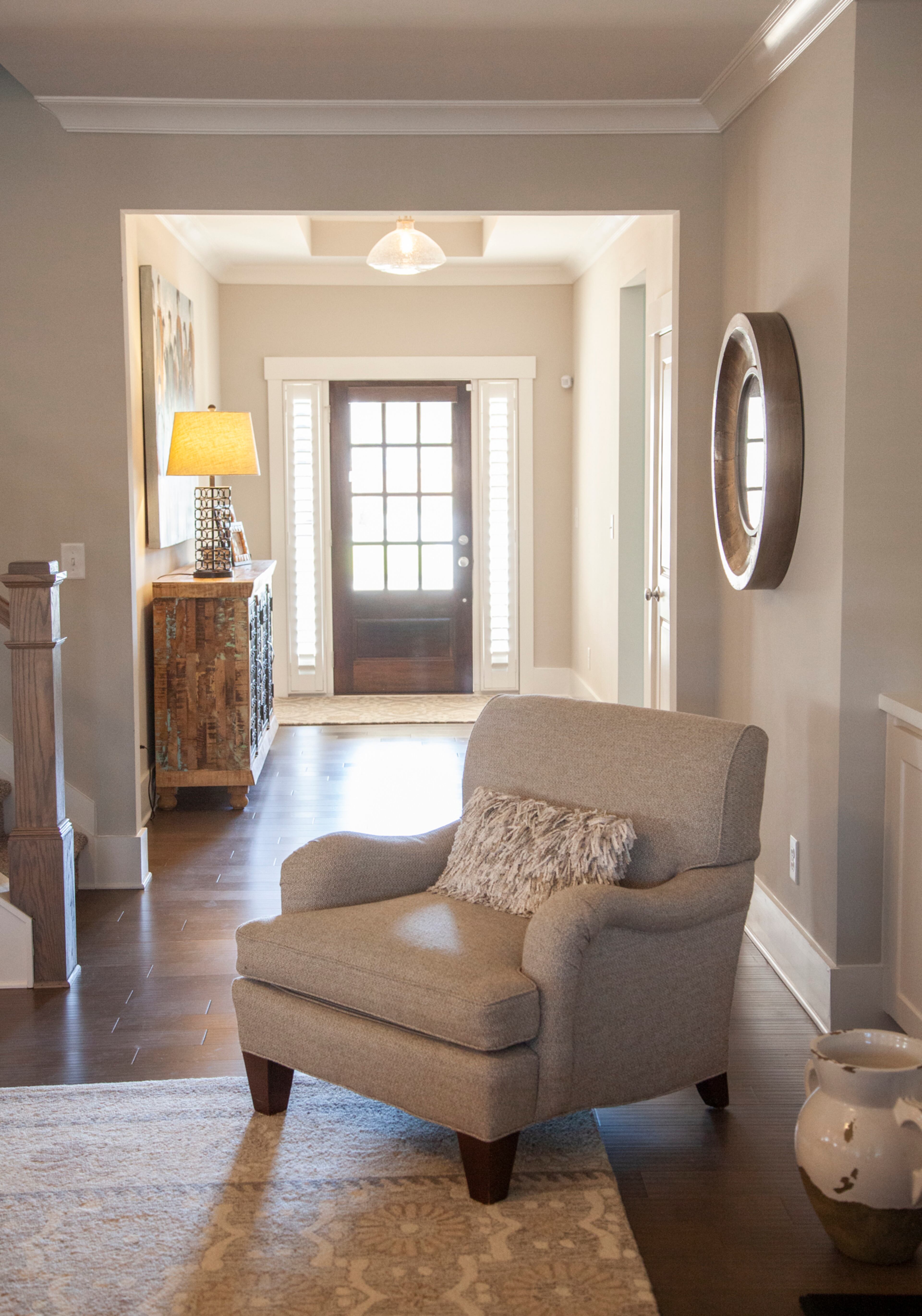 An entry hall ushers guests into the open living-kitchen area. Natural light pours in through the front door and sidelights. The chair was reupholstered by The Bronze Monkey in Marietta. Text by Kat Khoury/Fast Copy News Service. Photo by Reann Huber.