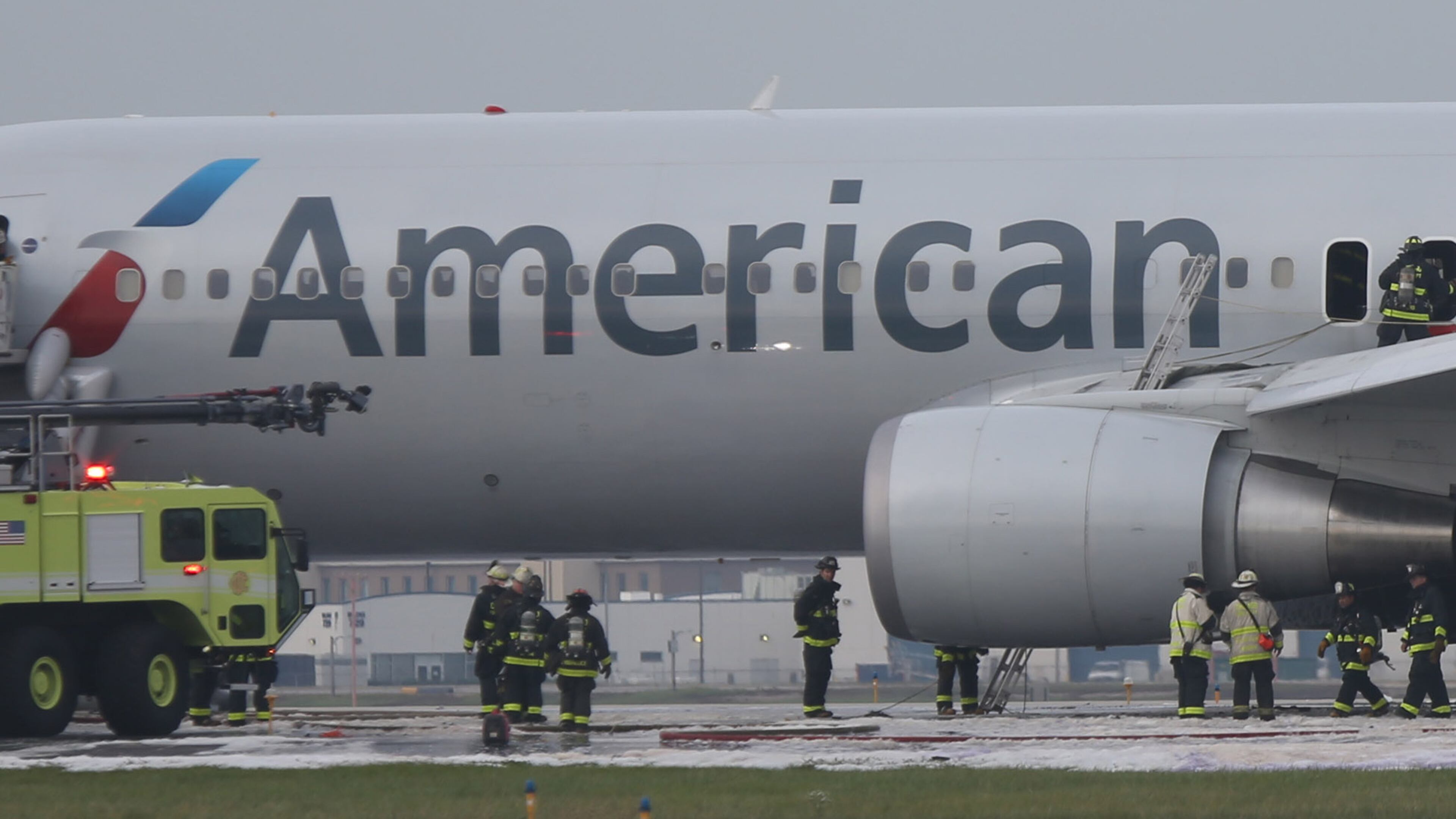 A fire-damaged American Airlines jet is checked over by Chicago firefighters following a blaze on the jet at O'Hare International Airport in Chicago on Friday, Oct. 28, 2016. (Antonio Perez/Chicago Tribune/TNS)