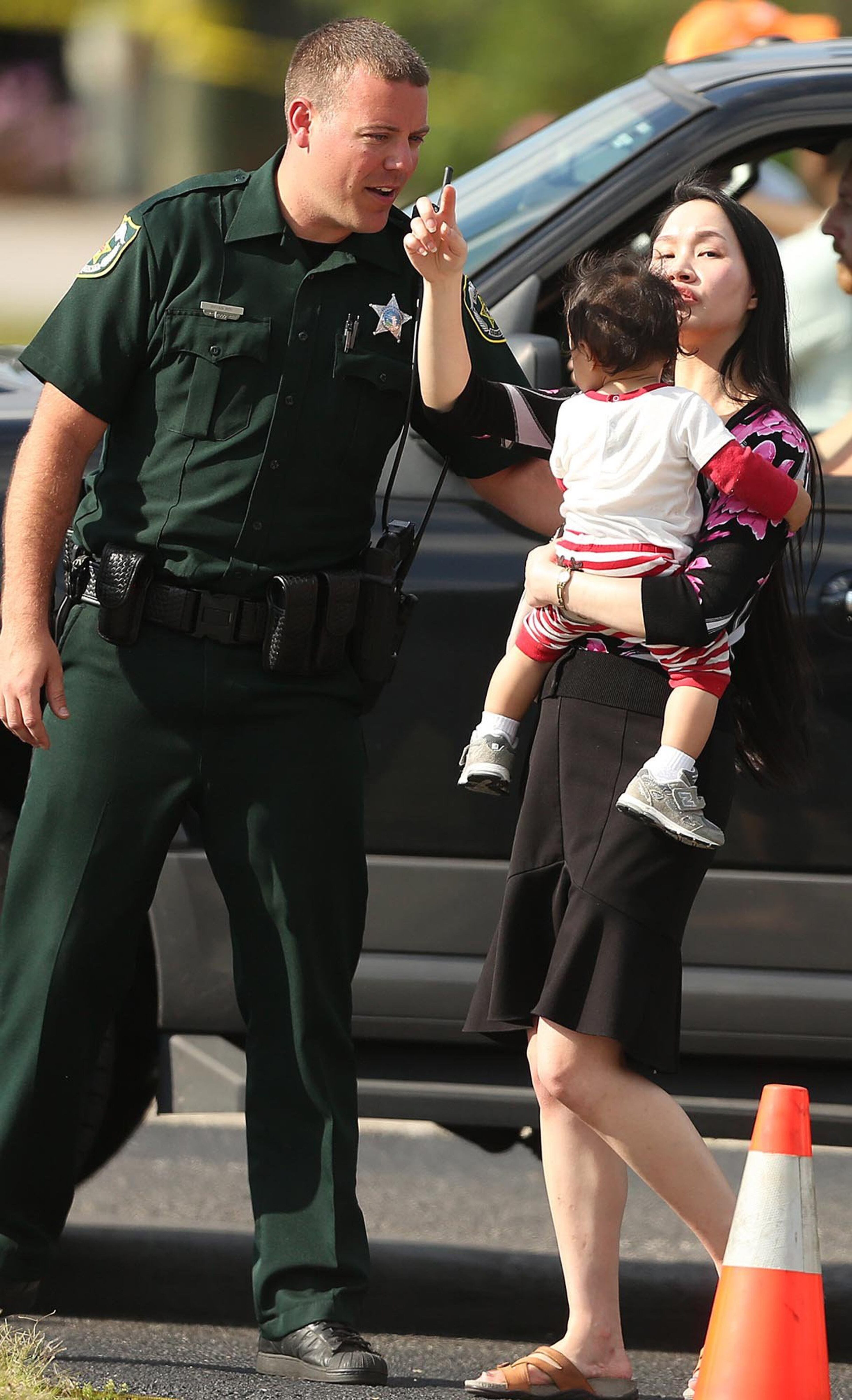 Children are escorted by their parents from the KinderCare Learning Center in Winter Park, Fla., a car crashed into the center on April 9, 2014. (Stephen M. Dowell, Orlando Sentinel/MCT)