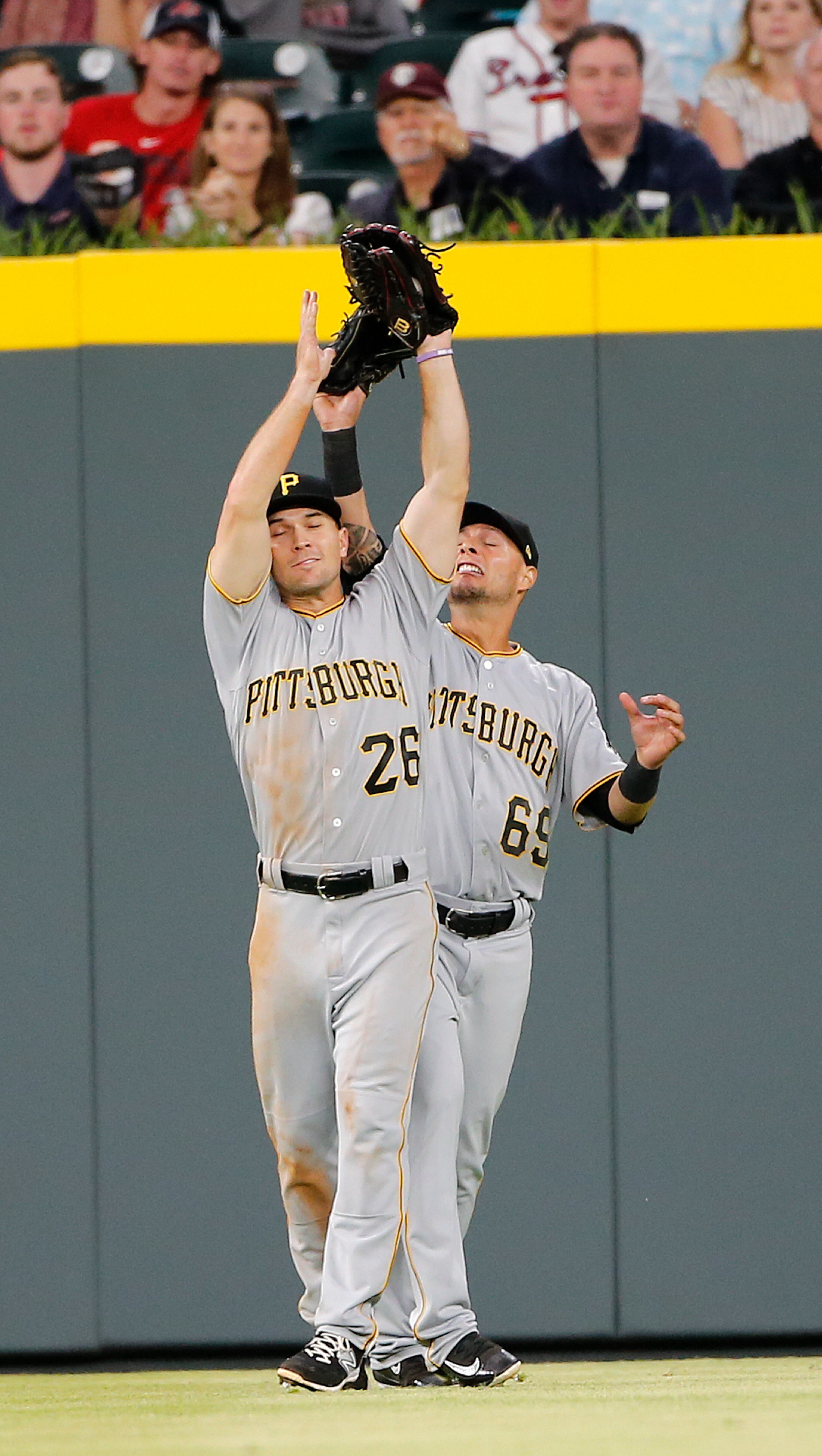 Pittsburgh Pirates left fielder Adam Frazier (26) steps in front of Pittsburgh Pirates centerfielder Danny Ortiz (69) to catch a fly ball off the bat of Atlanta Braves' Ender Inciarte in the fifth inning of a baseball game, Wednesday, May 24, 2017, in Atlanta. (AP Photo/John Bazemore)