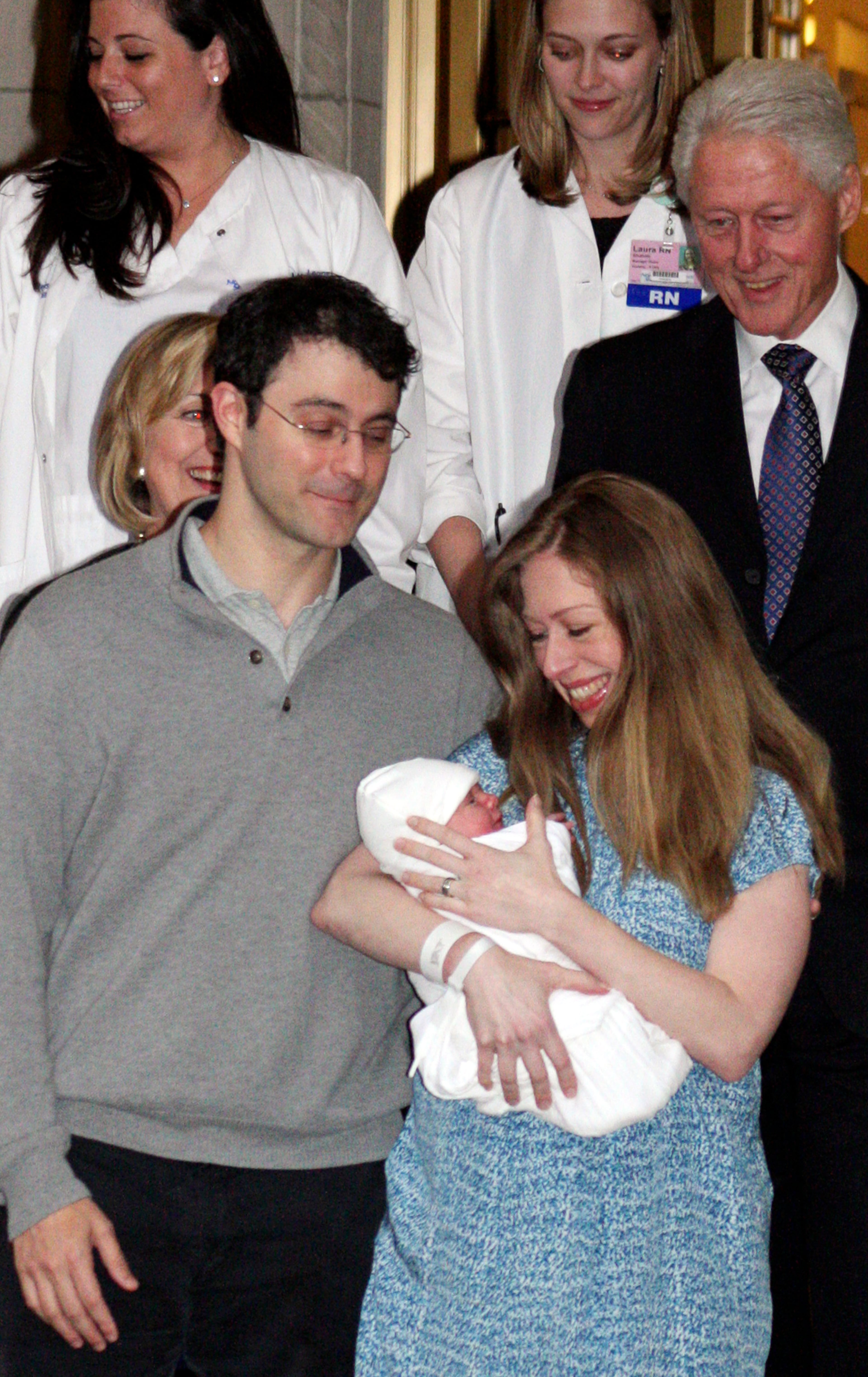 Hillary Clinton, partially visible left, her husband Bill Clinton, far right, their daughter Chelsea Clinton, center, her newborn baby, Charlotte, and Chelsea's husband Marc Mezvinsky leave Manhattan's Lenox Hill hospital in New York, Monday, Sept. 29, 2014. Charlotte was born Friday, Sept. 26, 2014. (AP Photo/William Regan)