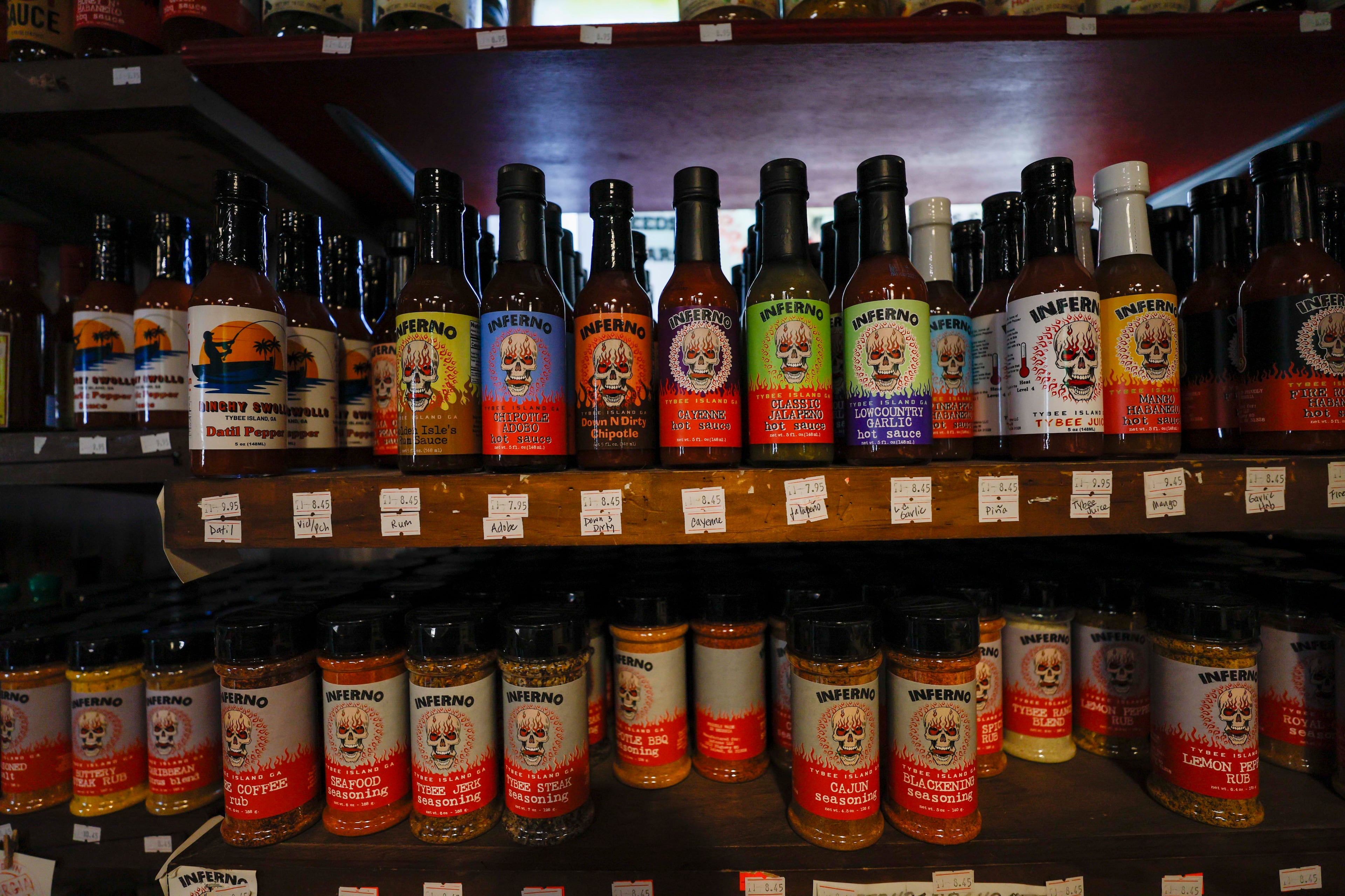 Multiple hot sauce products are displayed at the Inferno Hot Sauce Emporium on Tybee Island on Thursday, Jan 14, 2026. (Miguel Martinez/AJC)