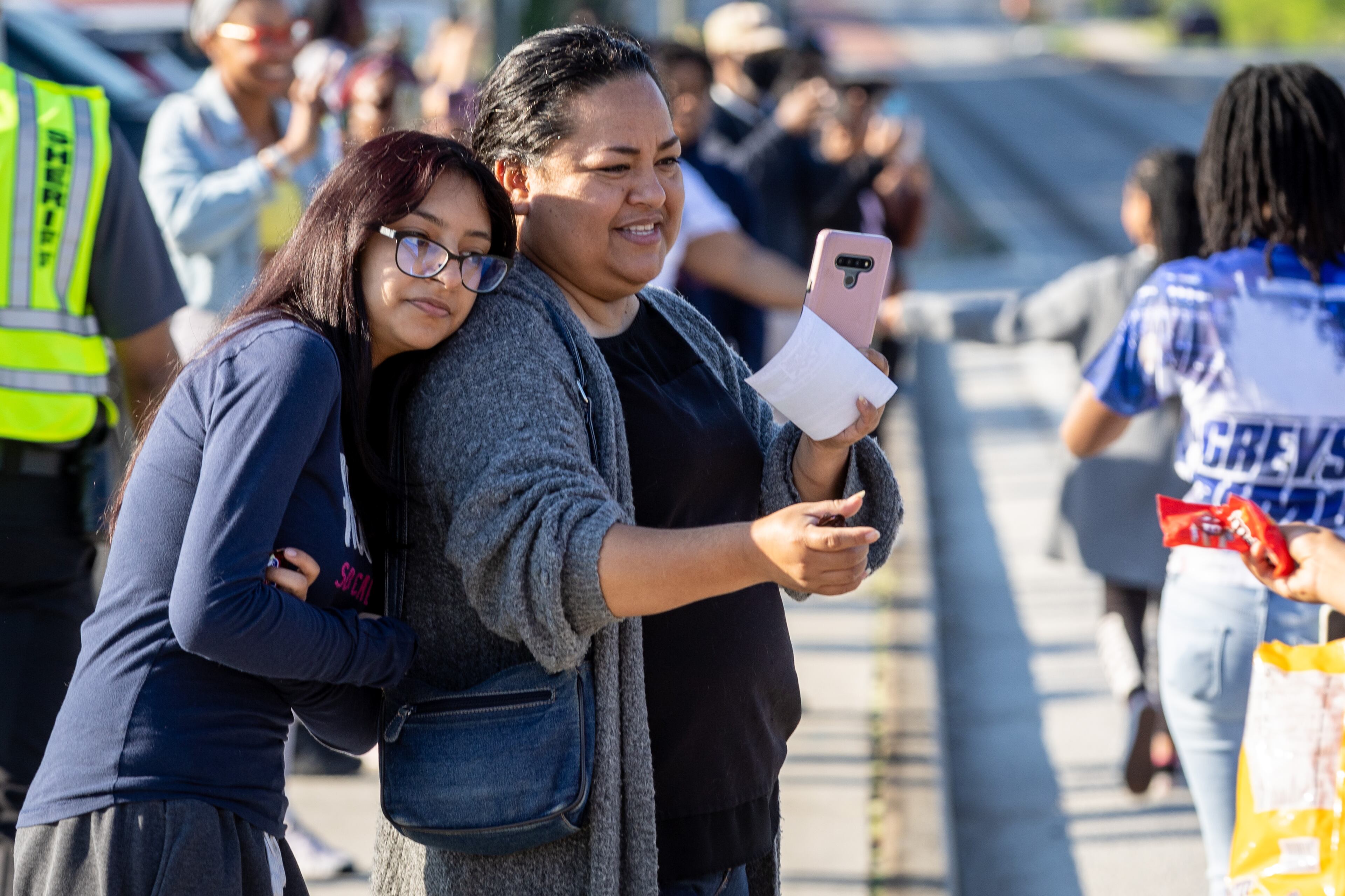 Vicenta Ruiz and her daughter Sarai Tranco watch the second Taste Of Mableton Festival parade head down Floyd Rd Saturday, April 15, 2023. (Steve Schaefer/steve.schaefer@ajc.com)