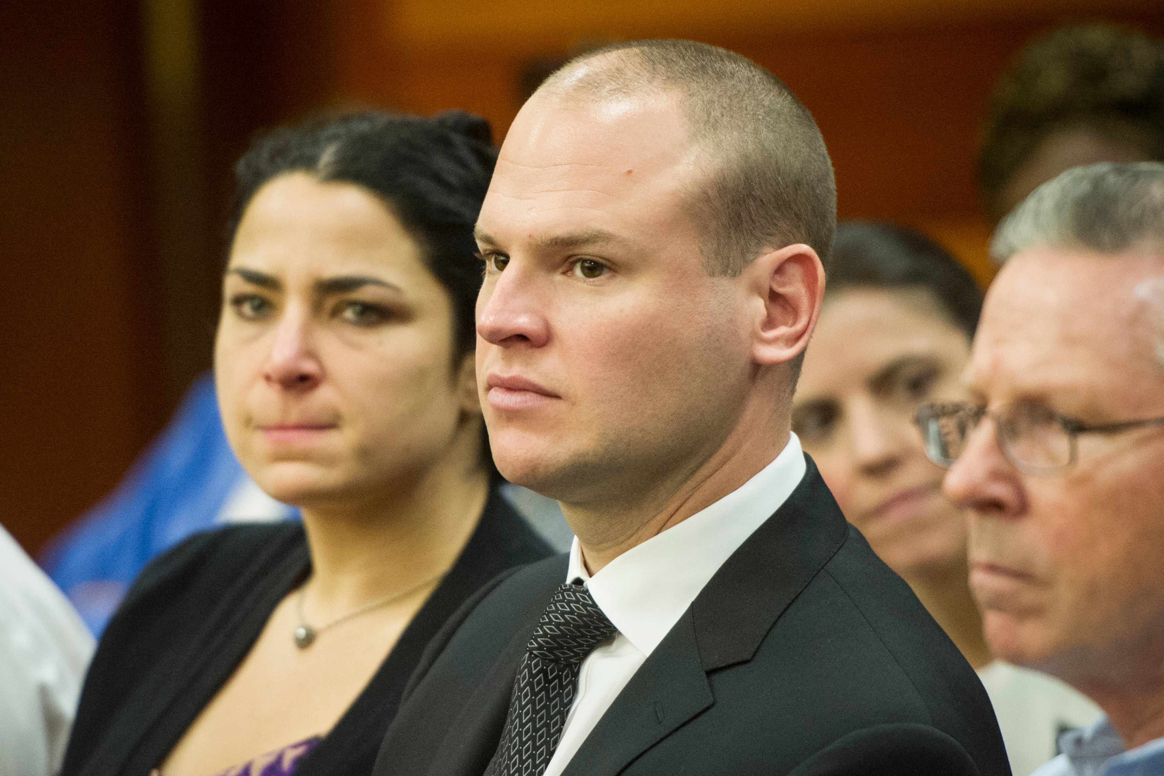 James Burns is flanked by his father, Richard Burns, and his wife, Lindsey Burns, during a preliminary hearing on August 1, 2016, in Atlanta. Burns is the former Atlanta police officer accused of murder in the shooting death of Deravis Caine Rogers.