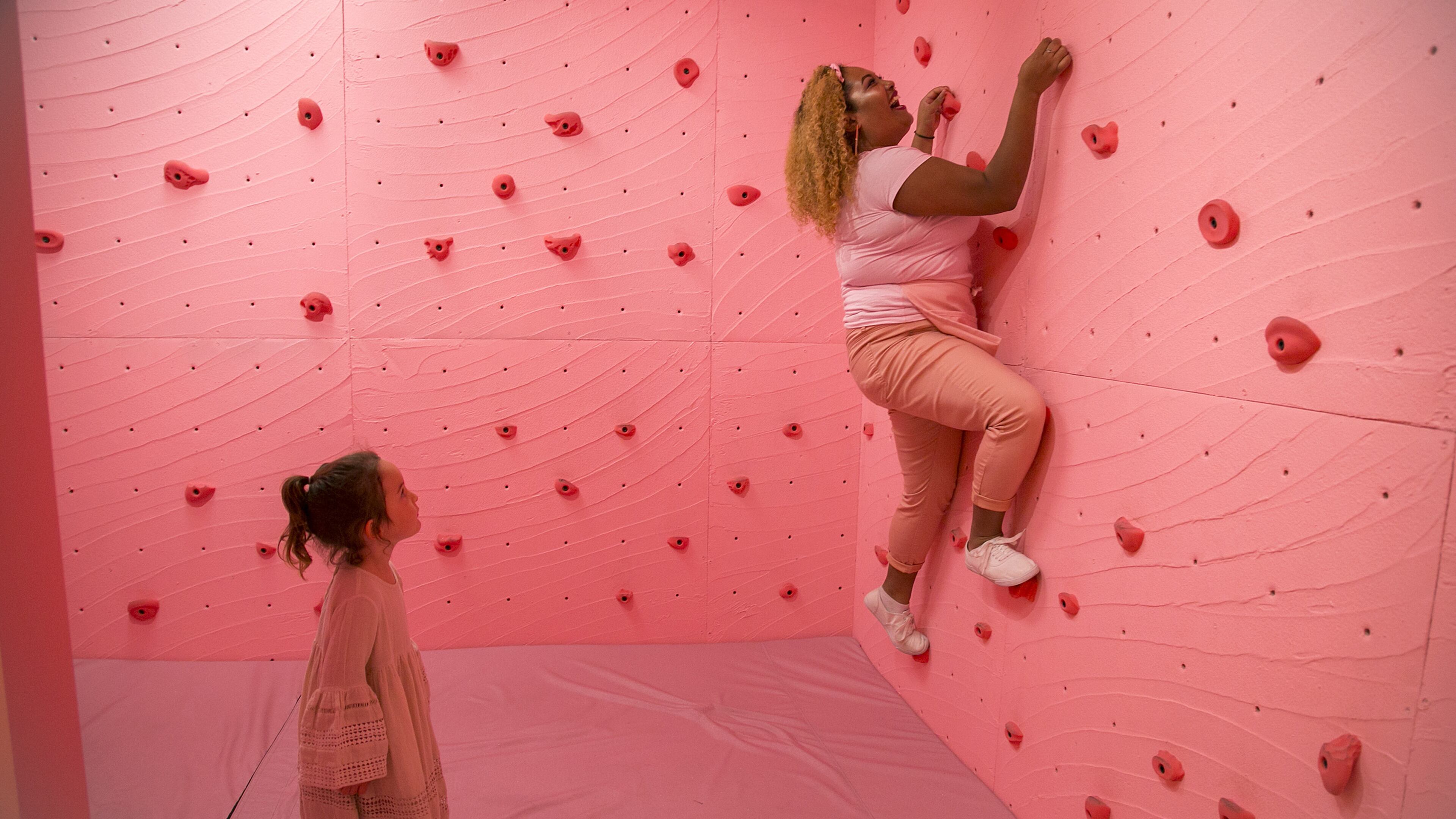 Orion Montoya watches as Allyson "Ally Mode" Santa Maria climbs the Rock Candy Cave wall at the Museum of Ice Cream in San Francisco on September 14, 2017. (LiPo Ching/Bay Area News Group/TNS)