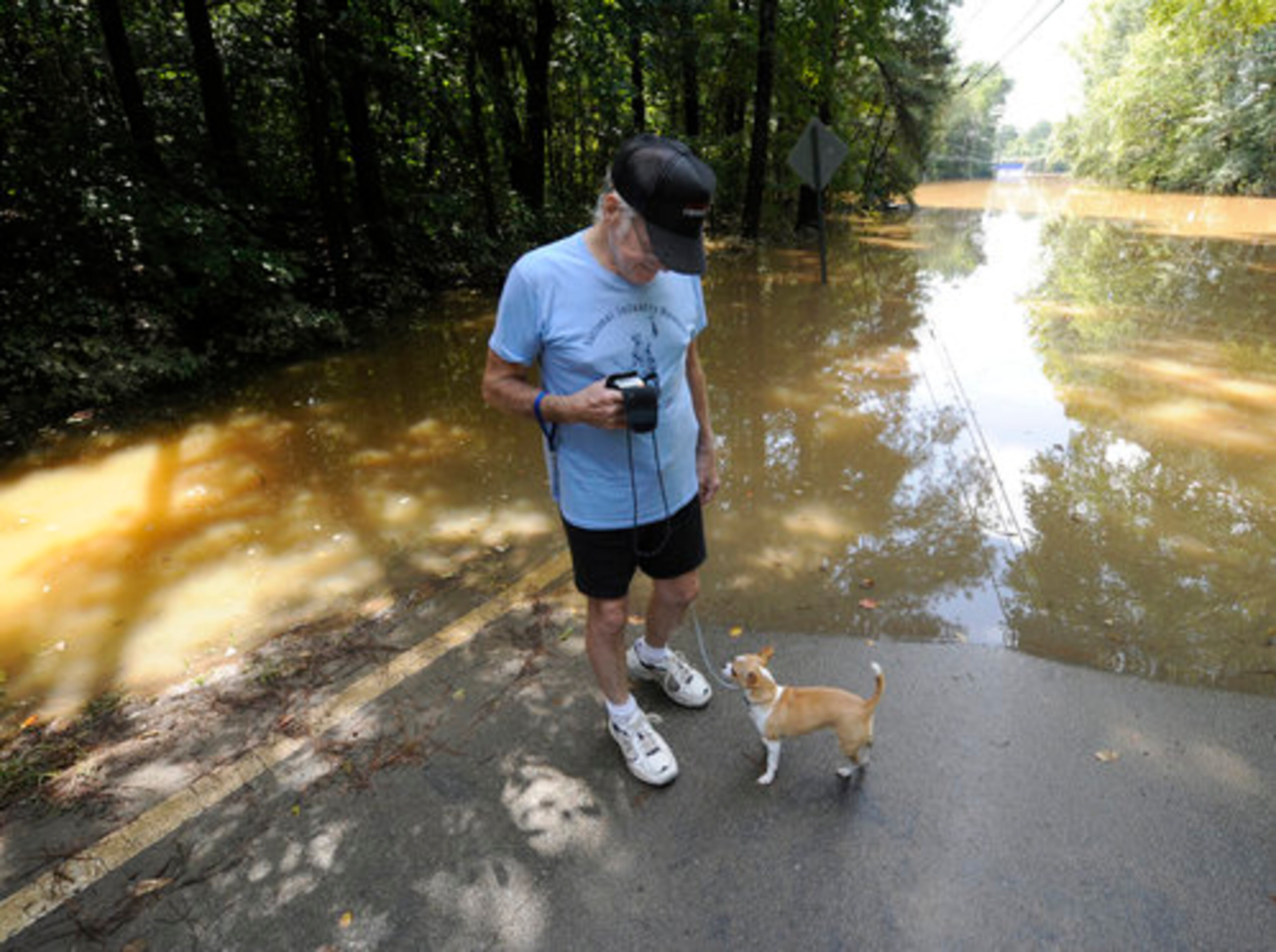 Austell's Sylvester Cheek walks his dog Taffie to the edge of Old Alabama Road so she can check out the walking route.