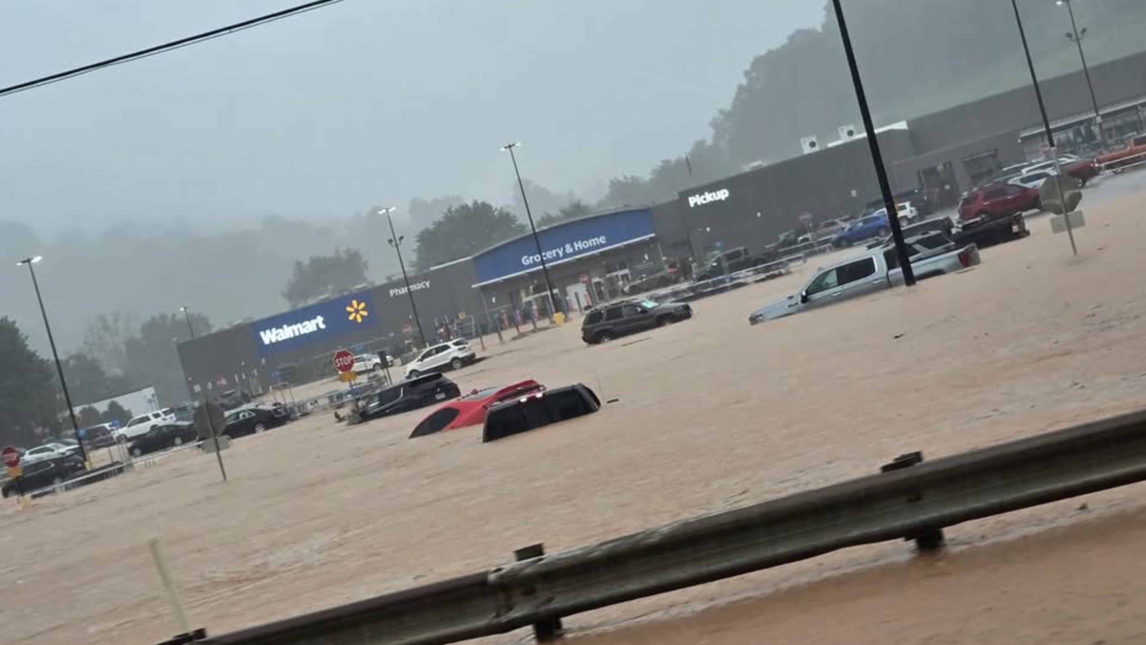 In this photo provided by Alexis Wood, a flooded Walmart parking lot is shown Tuesday, July 21, 2026, in Weston, W.Va. (Alexis Wood via AP)