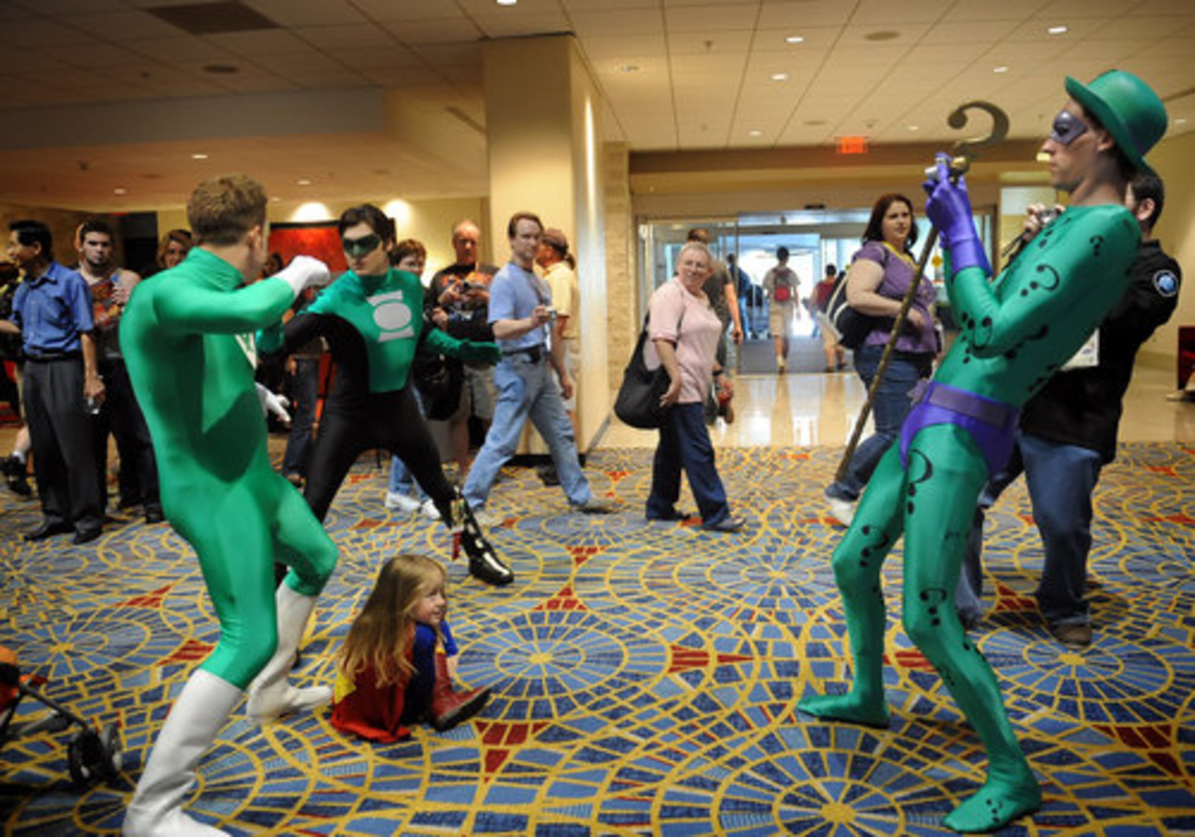 Laban Boldero (left), dressed as Power Ring, Harrison Beahn (second from left), dressed as Green Lantern, and Boldero's 4-year-old daughter Madison pose as Matthew Knight (right), dressed as The Riddler, takes their picture at the Atlanta Marriott Marquis on Friday. More than just people-watching goes on at the DragonCon convention, which also features autograph opportunities and a dealers room.