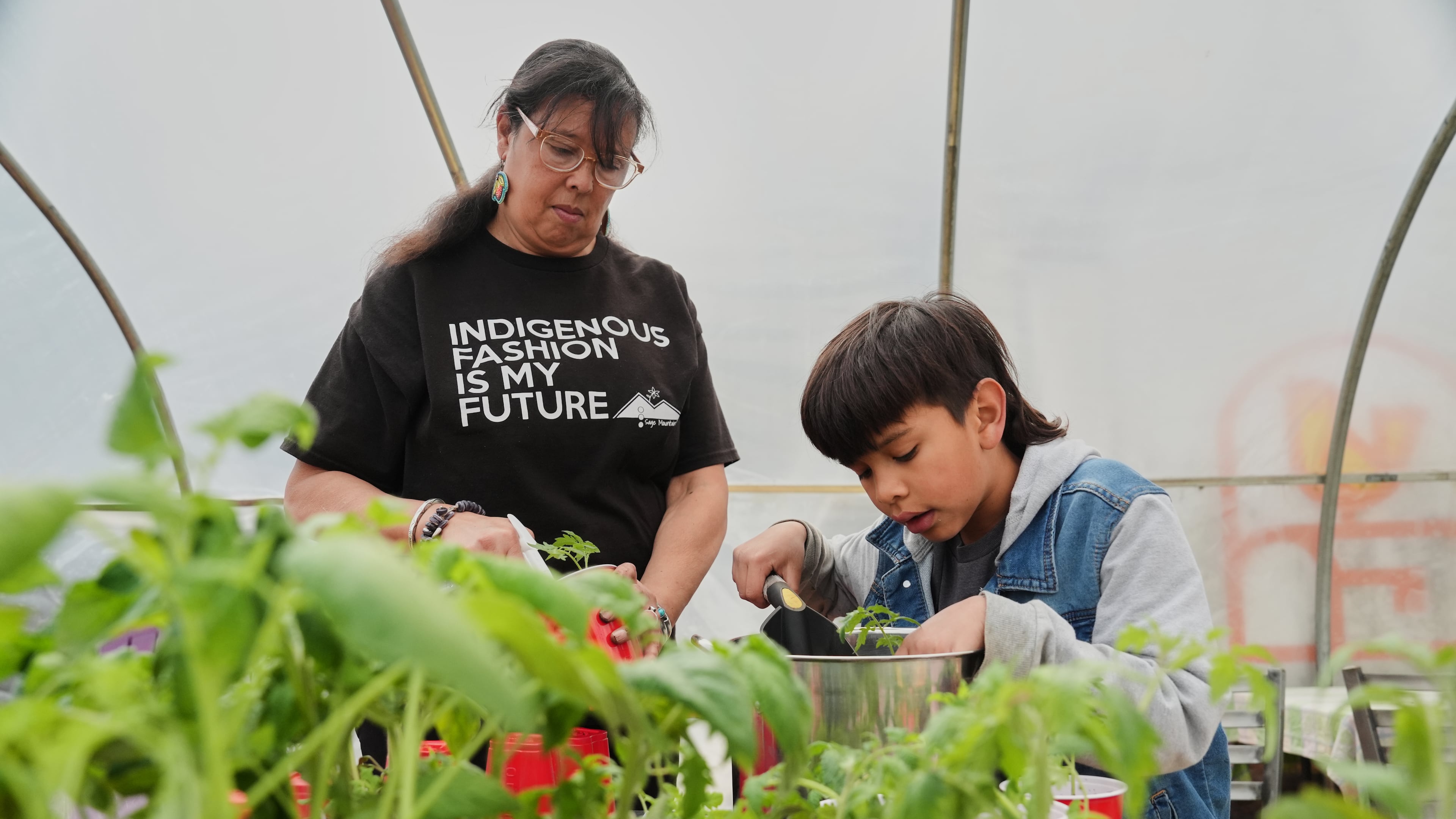 Dawn Spears, left, and her grandson, Giizhig, 9, right, prepare tomatoes for planting Tuesday, April 21, 2026, at a farm in Hopkinton, R.I. (AP Photo/Joshua A. Bickel)