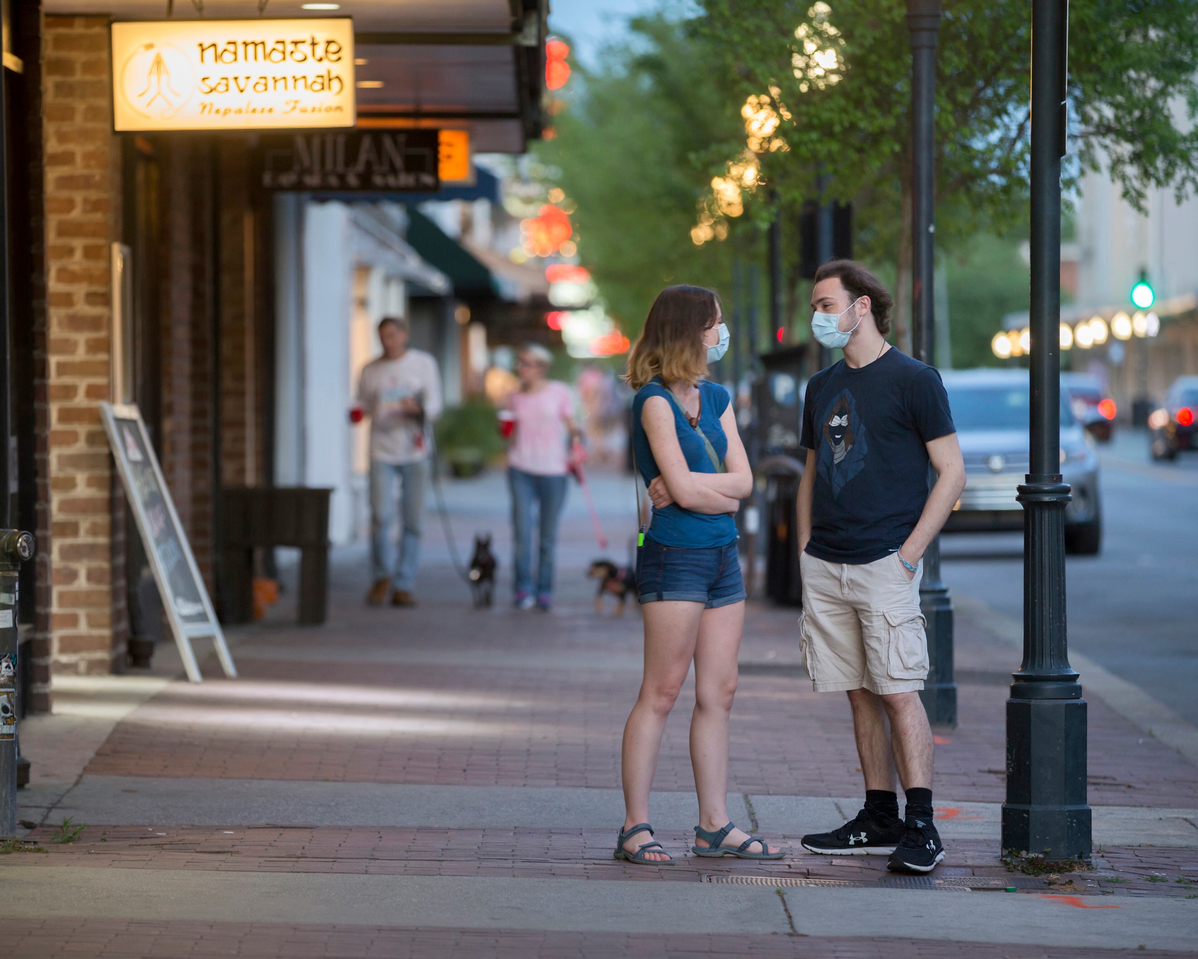 SAVANNAH, GA - APRIL 4, 2020: Wearing masks for protections, two Savannah College of Art and Design students wait for their togo order at a local restaurant on Broughton Street in the Historic Downtown Neighborhood. (AJC Photo/Stephen B. Morton)