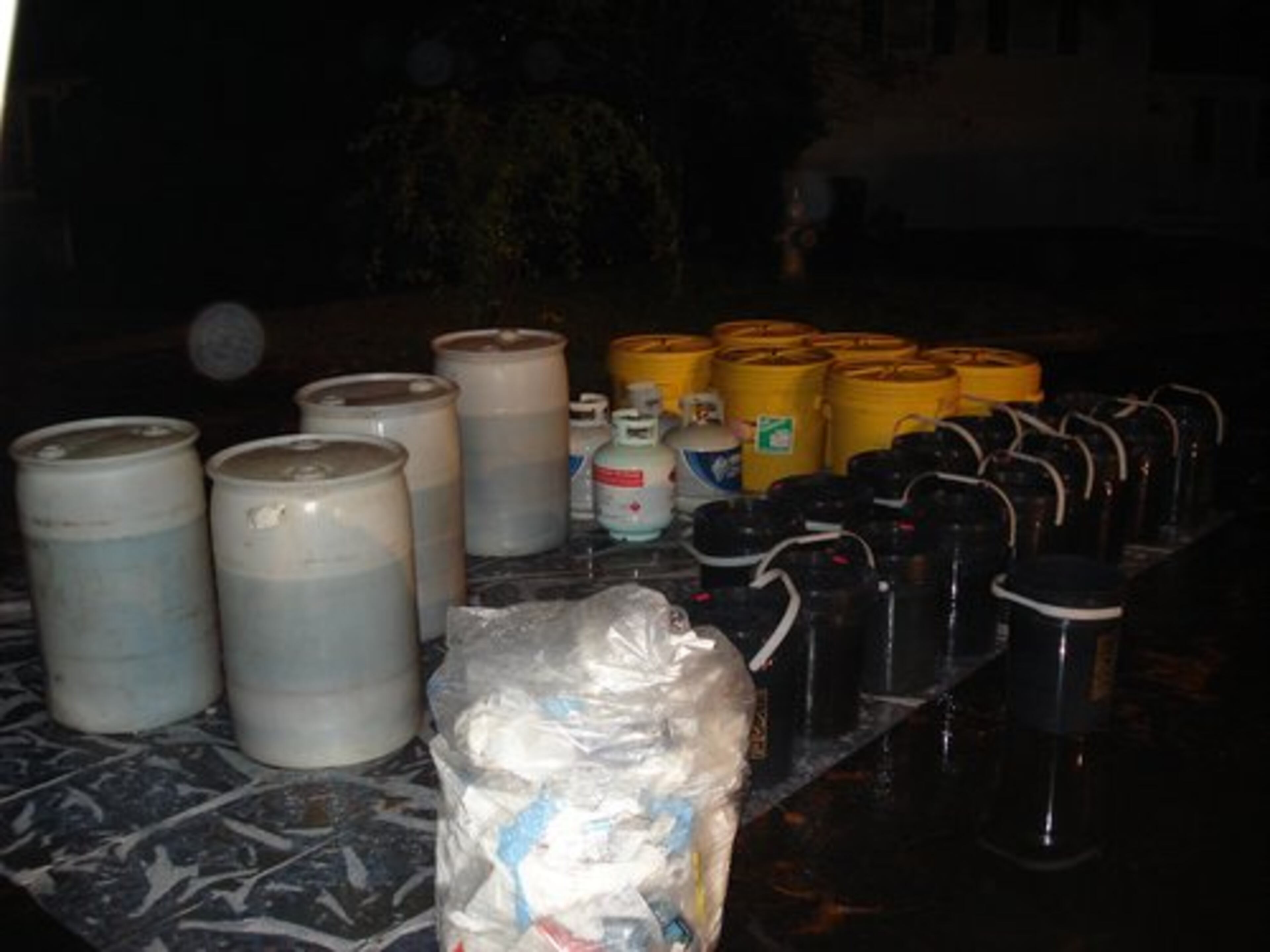 Authorities in hazmat suits spent the night removing items from a suspected drug house in Norcross.