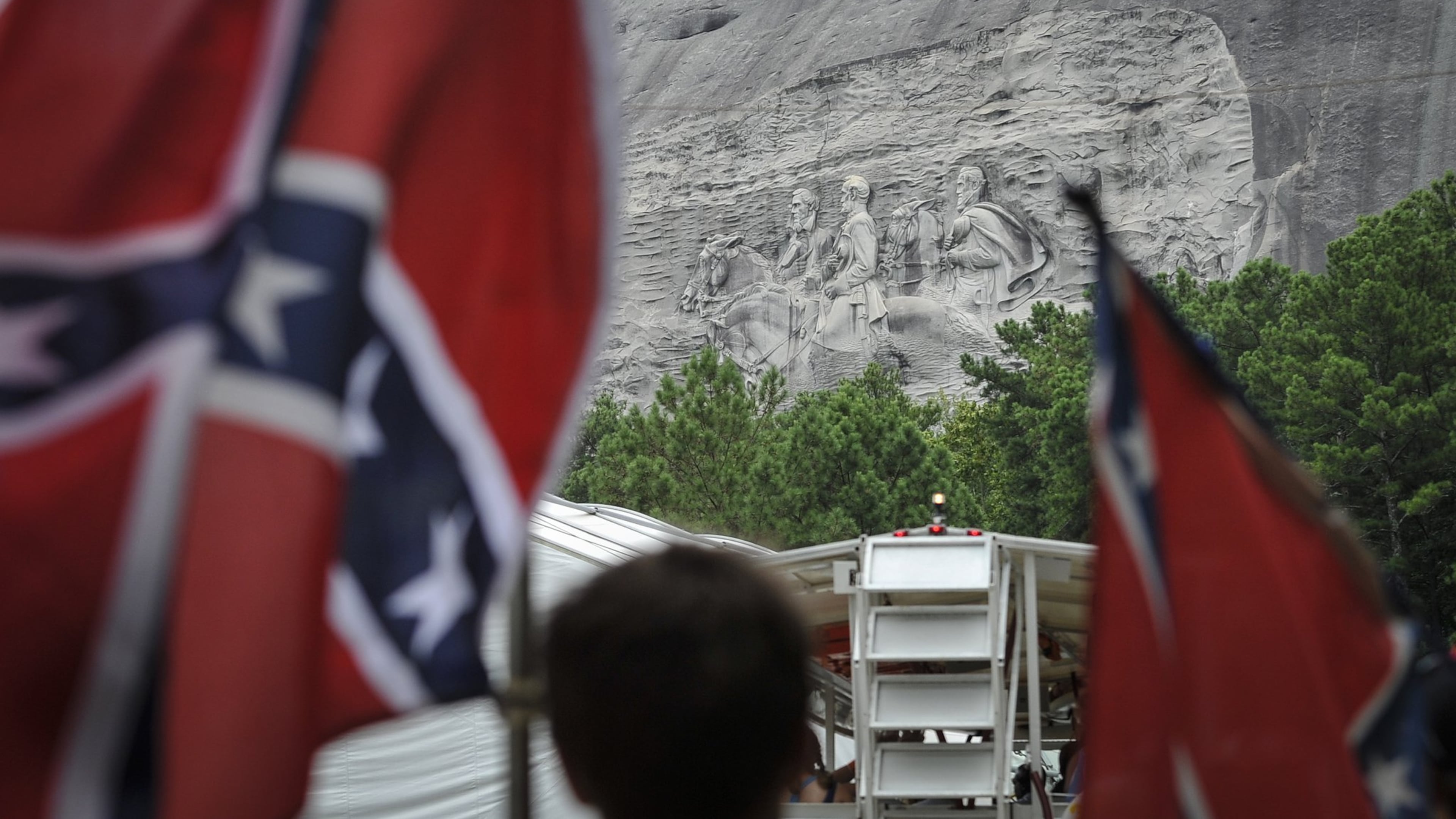 Confederate flag sympathizers march past the carved monument at Stone Mountain Park in protest of what they believe is an attack on their Southern heritage. (John Amis / AJC 2015 file photo)