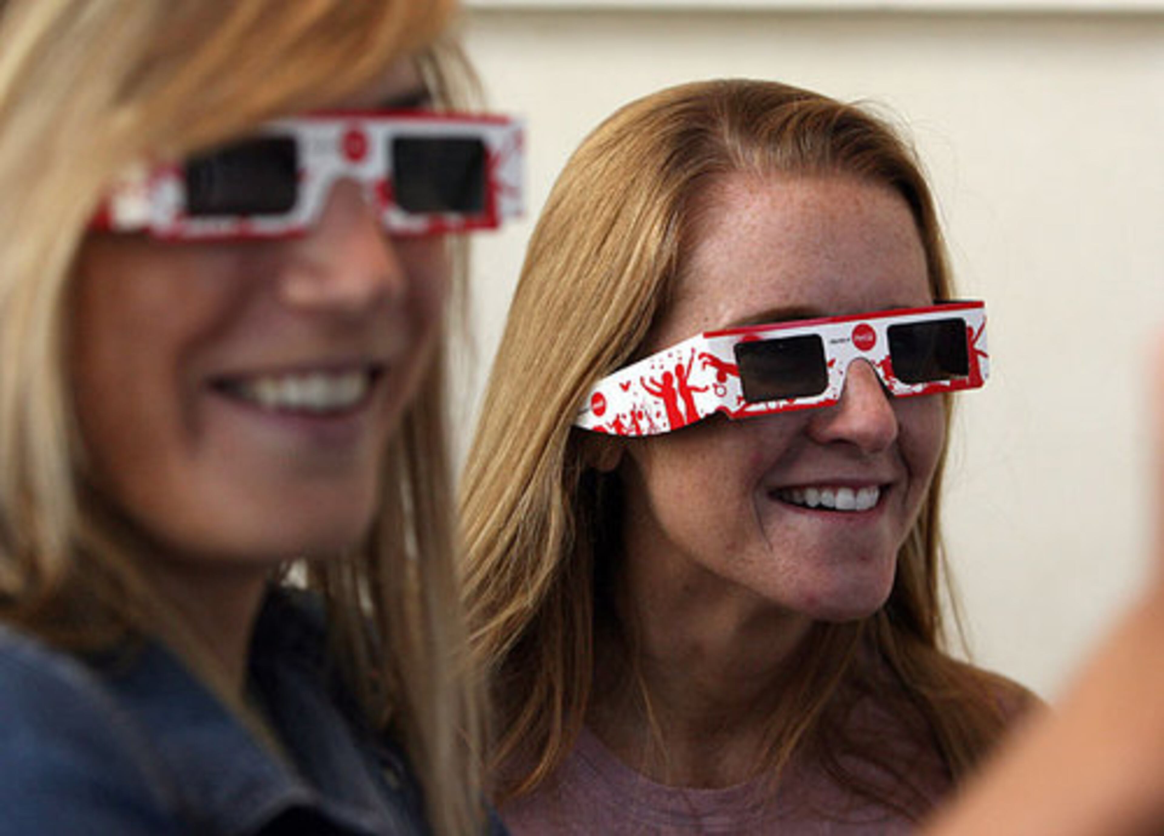 Marissa Roy, and Patti Pruetttry out their viewing glasses as they wait in line for the Secret Formule 4-D Theater at the New World of Coca-Cola grand opening May 24, 2007 in downtown Atlanta.