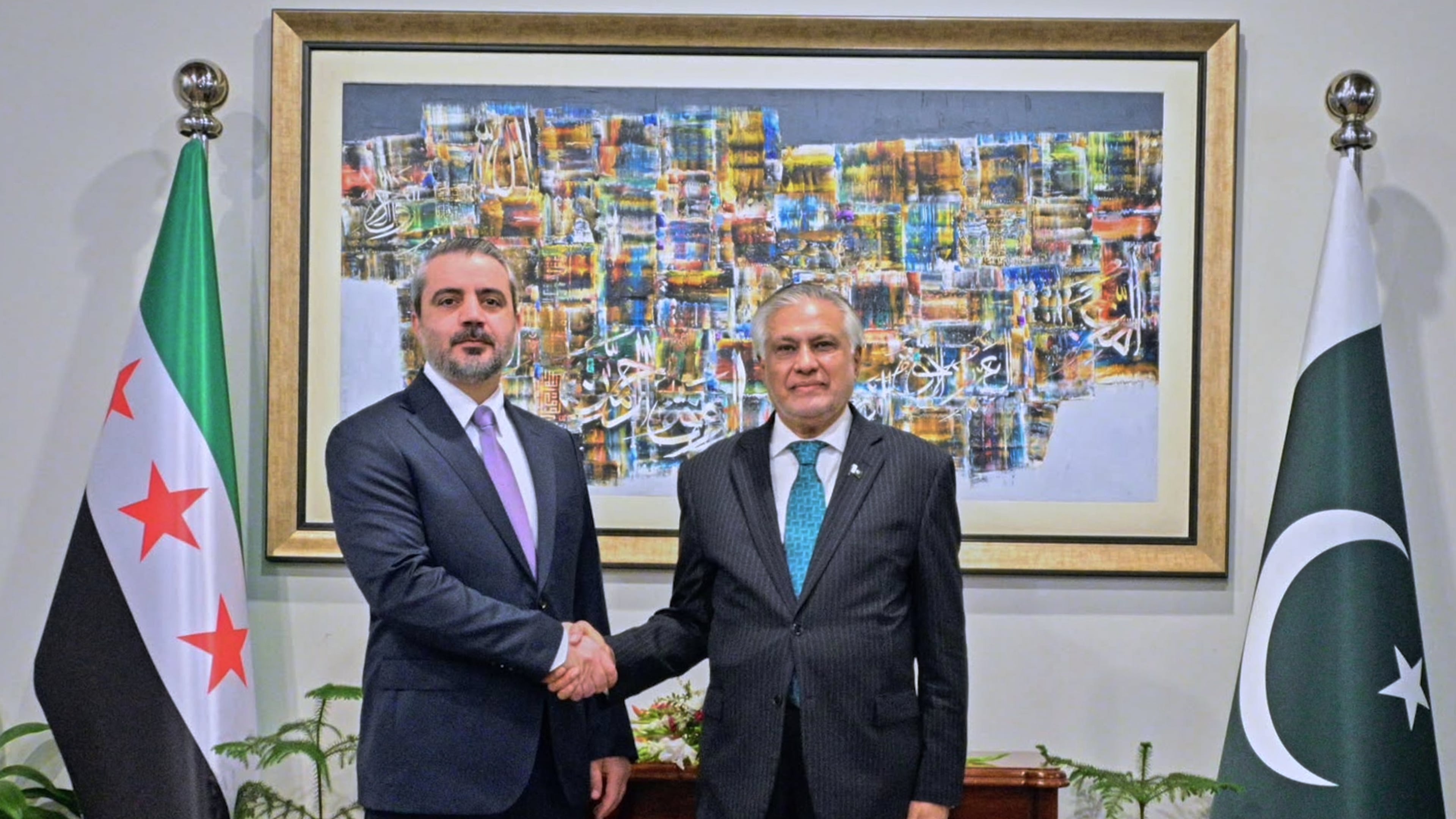In this photo released by the Pakistan Ministry of Foreign Affairs, Syrian Foreign Minister Asaad Hassan al-Shibani, left, shakes hands with his Pakistani counterpart Ishaq Dar before their meeting in Islamabad, Pakistan, Thursday, Aug. 20, 2026. (Pakistan Ministry of Foreign Affairs via AP)