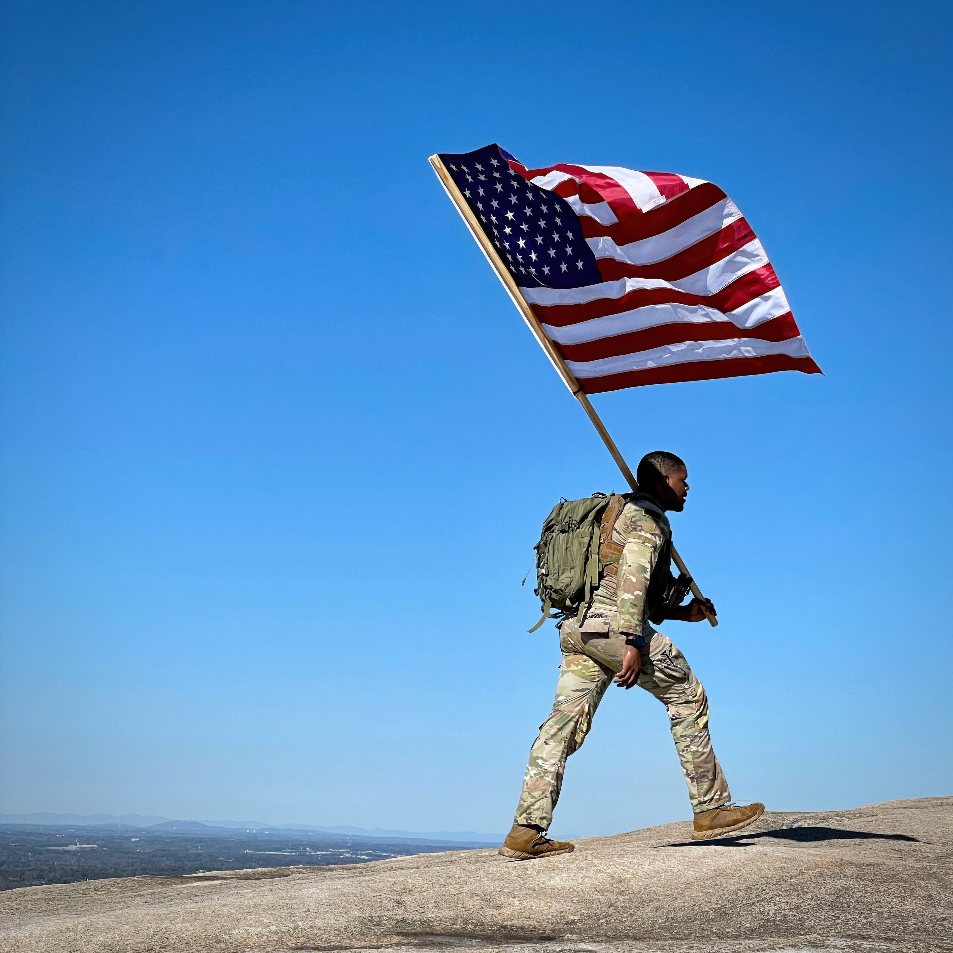 A soldier carries the U.S. flag to the top of Stone Mountain to honor three fallen U.S. Army reservists from Georgia killed in a drone attack in Jordan in January 2024. (Courtesy of Jean Shifrin)