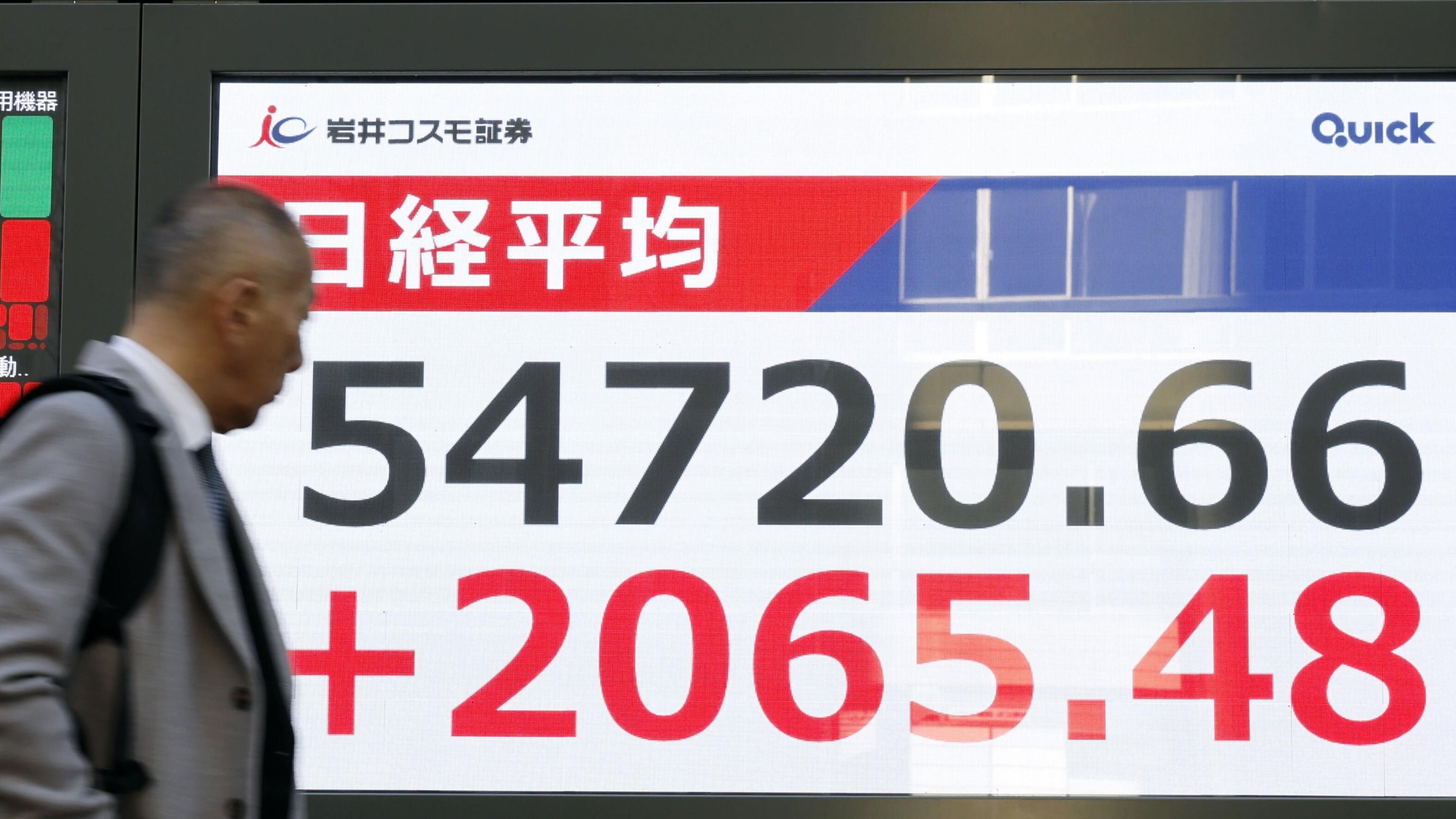 A person walks in front of an electronic stock board at a securities firm in Tokyo Tuesday, Feb. 3, 2026. (Masanori Kumagai/Kyodo News via AP)