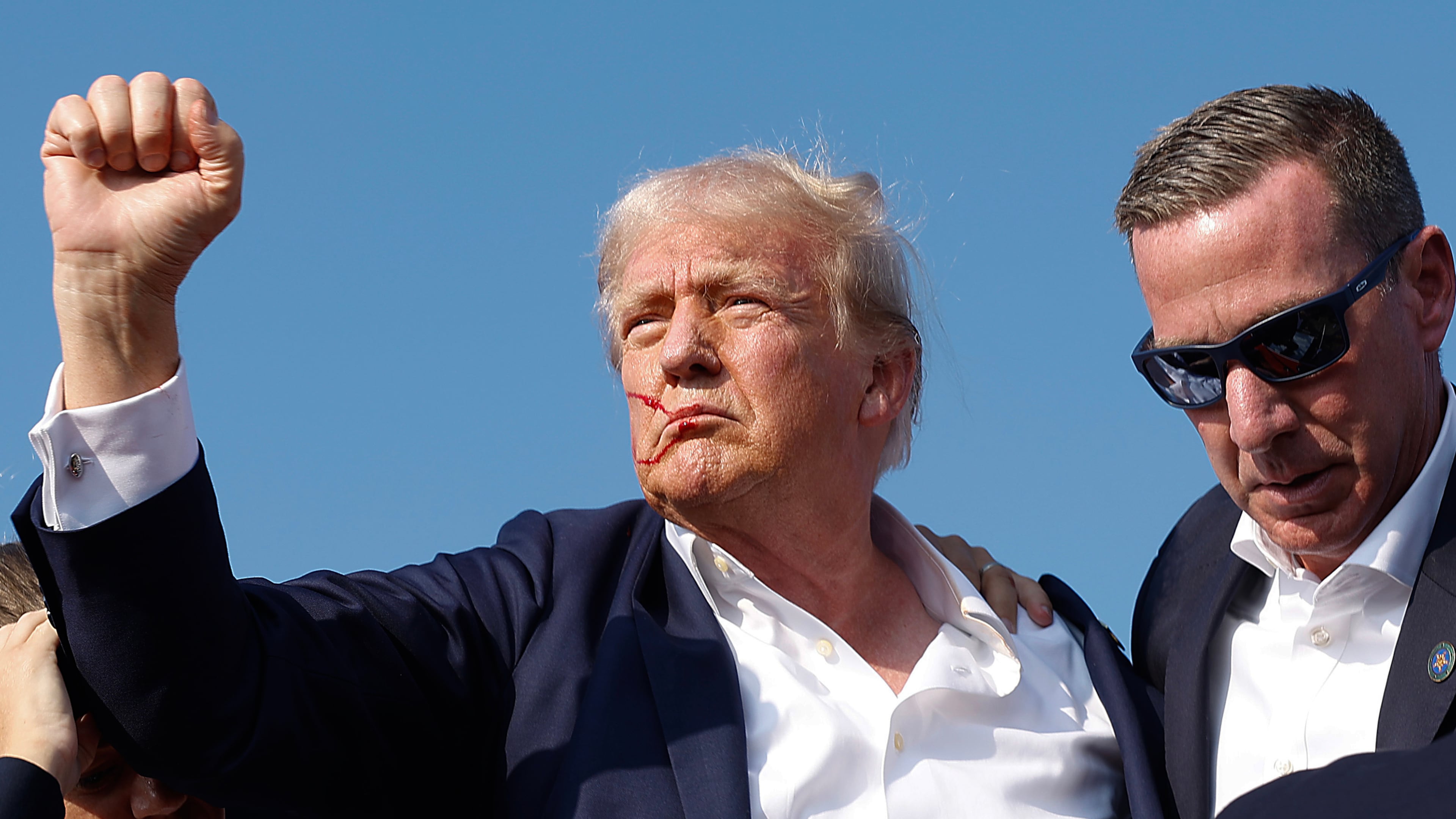 Former President Donald Trump pumps his fist July 13 as he is rushed offstage by Secret Service agents after being grazed by a bullet at a campaign rally in Butler, Pa. (Anna Moneymaker/Getty Images/TNS)