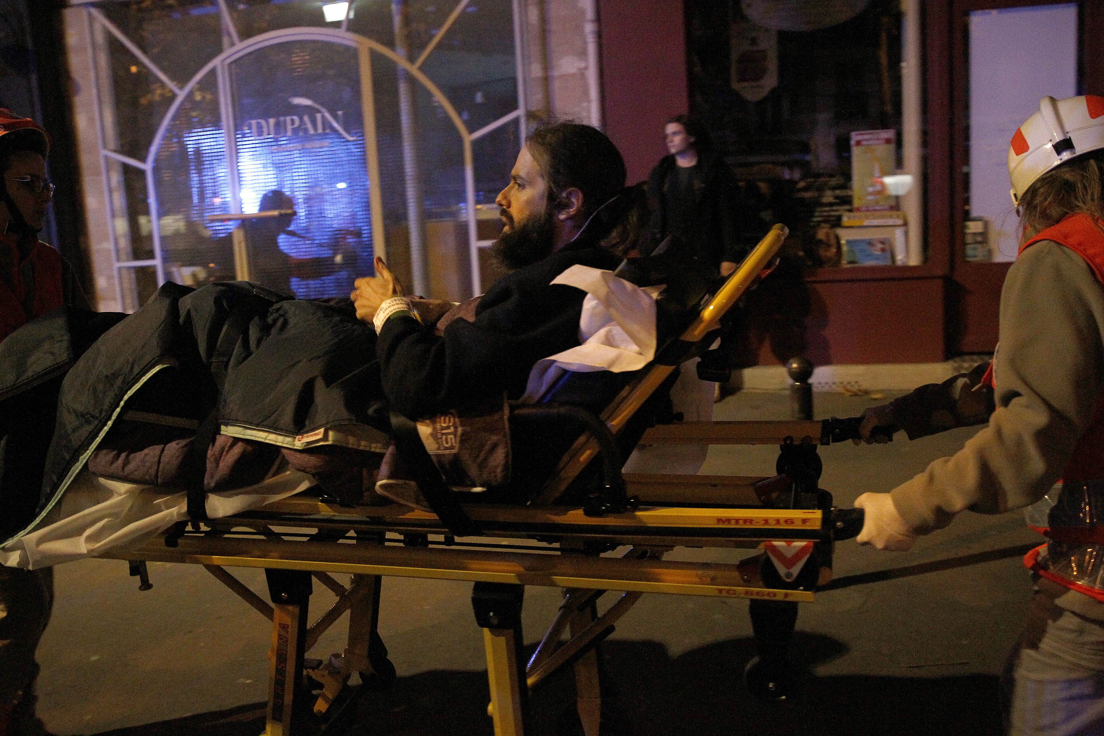 Rescuers evacuate an injured man on Boulevard des Filles du Calvaire, close to the Bataclan theater, early on November 14, 2015 in Paris, France. According to reports, at least 149 people were killed in a series of bombings and shootings across Paris, including during a soccer game at the Stade de France and a concert at the Bataclan theater. (Photo by Thierry Chesnot/Getty Images)