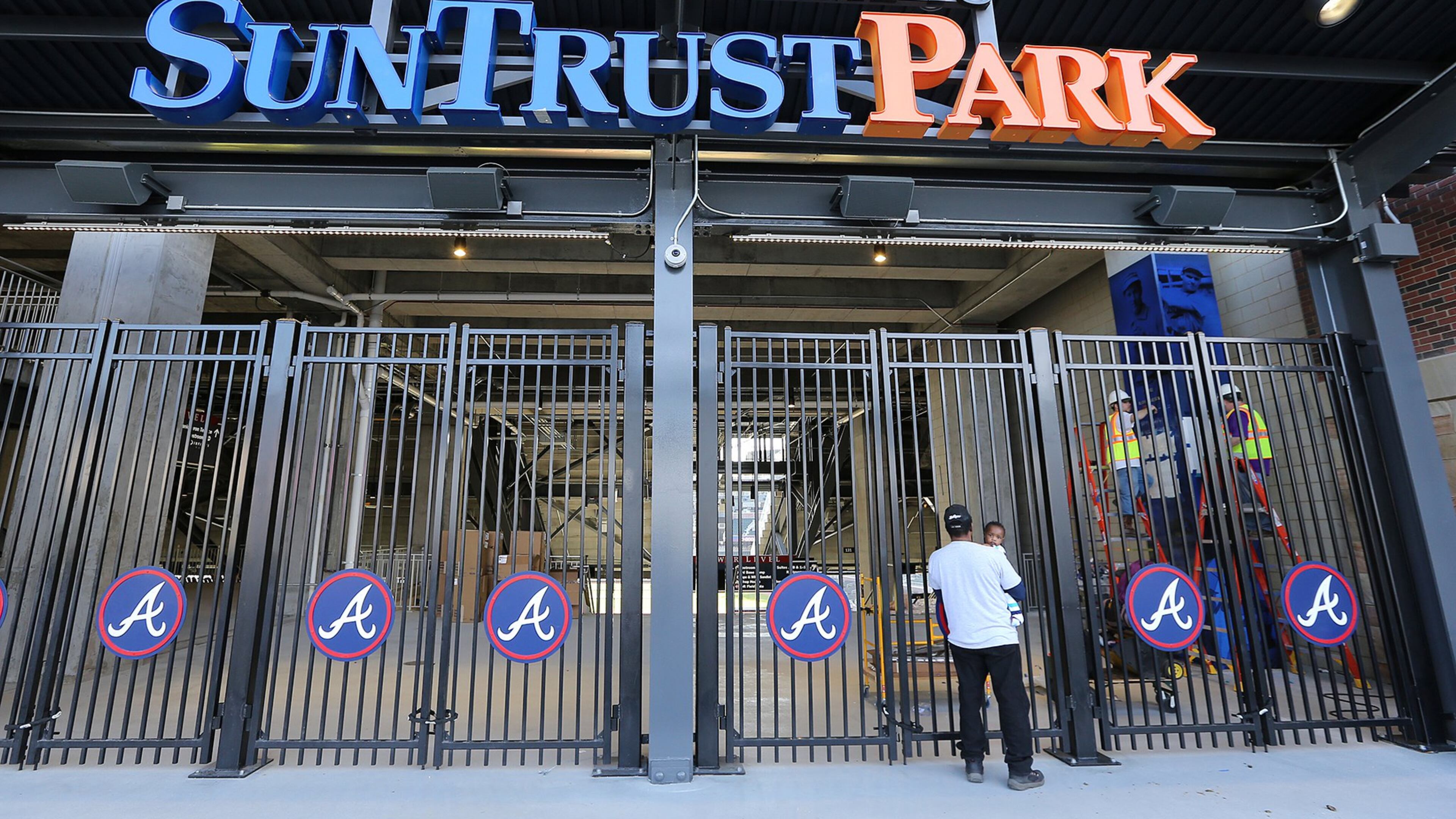 Melvin Jones, Marietta, and his 1-year-old grandson Deandre Jones, take a sneak peak of SunTrust Park, the new home of the Braves, through the third-base gate on Monday, March 20, 2017. (Curtis Compton/ccompton@ajc.com)