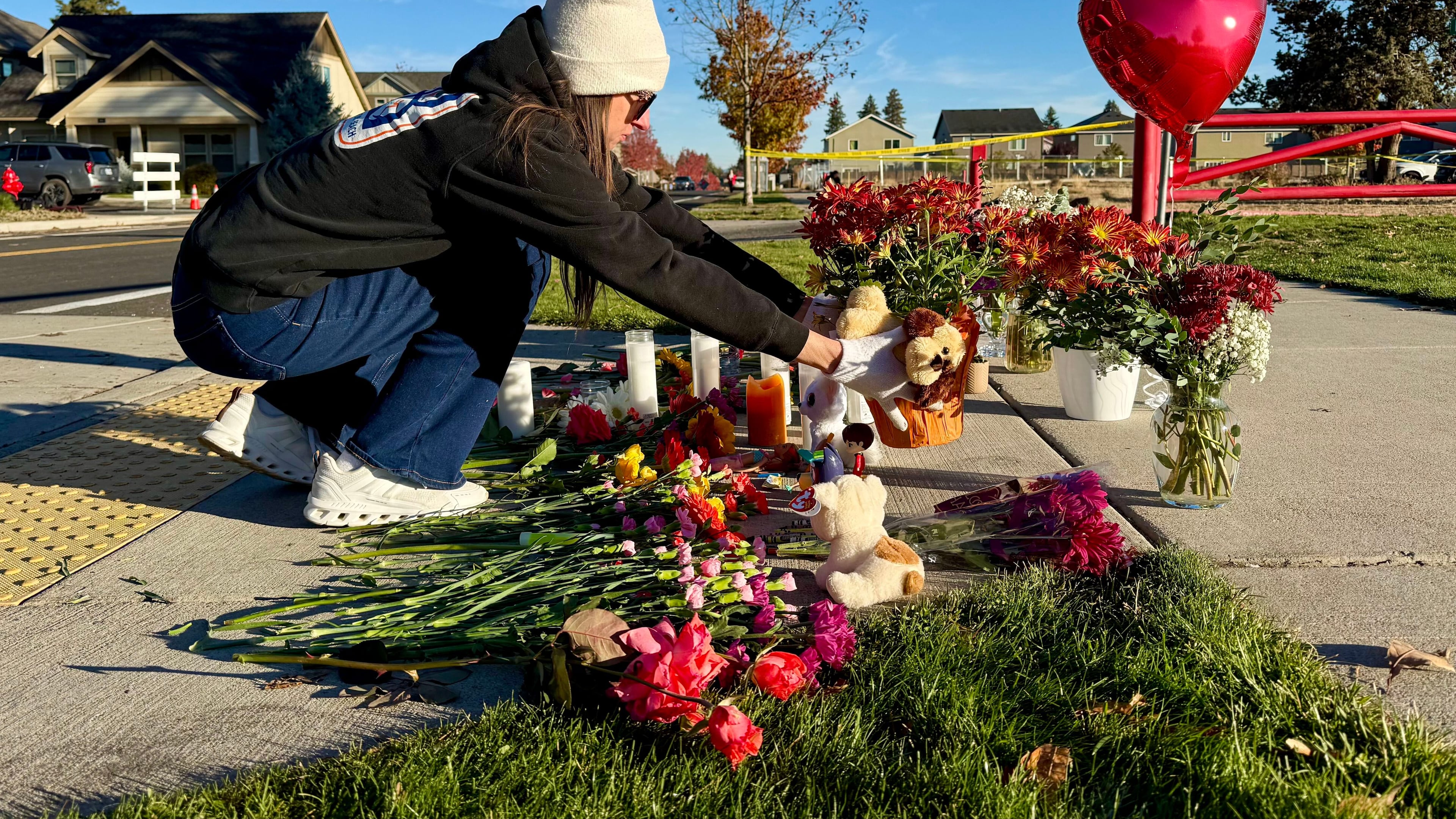 A person places flowers at a makeshift memorial on the other side of Silver Rail Elementary School in Bend, Ore., on Friday, Oct. 16, 2026, a day after a deadly shooting. (AP Photo/Haven Daley)