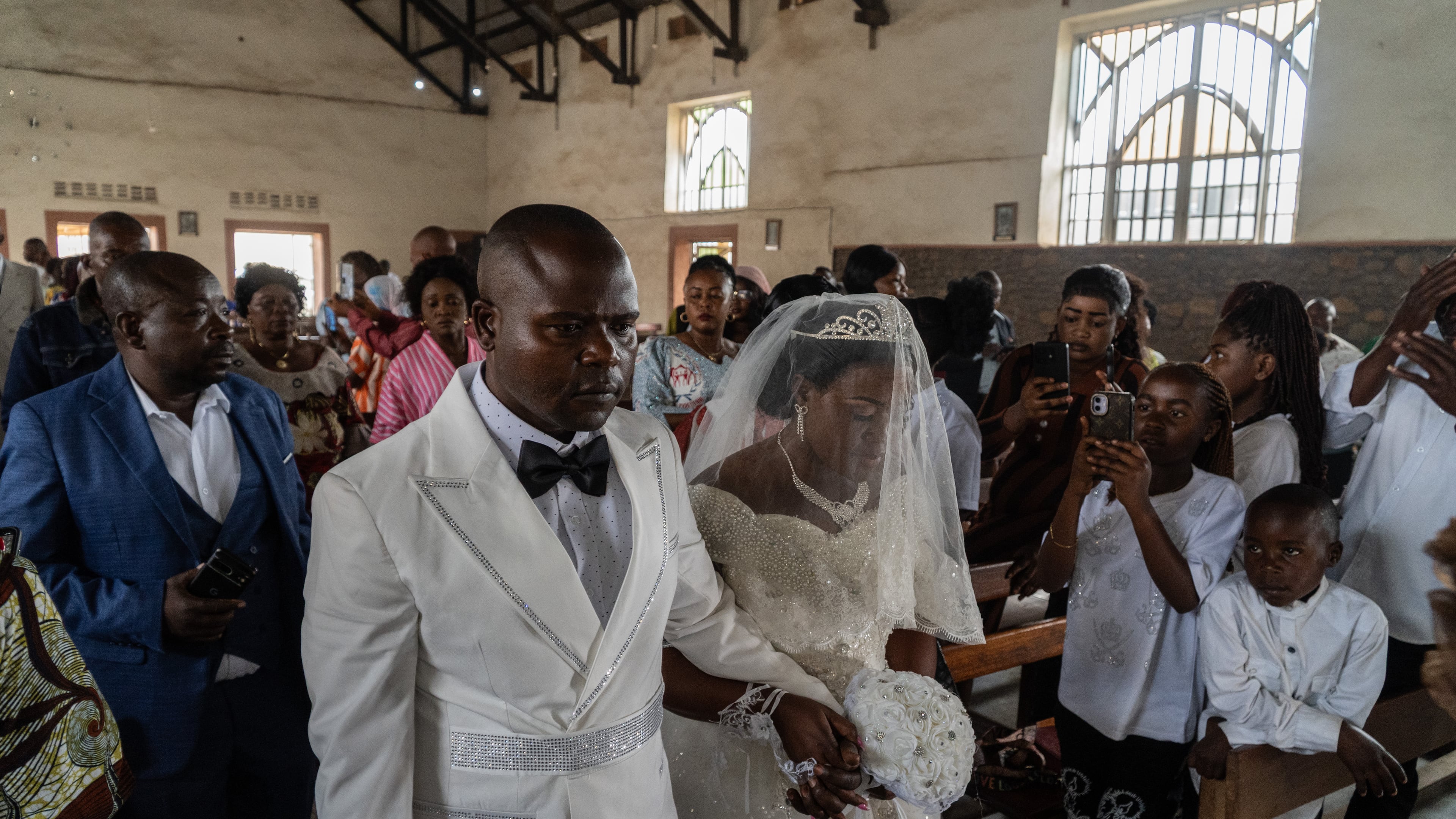 A newly married couple walks down the aisle at their wedding amid an Ebola outbreak in Ituri Province in Bunia, Congo, Saturday, June 6, 2026. (AP Photo/Moses Sawasawa)