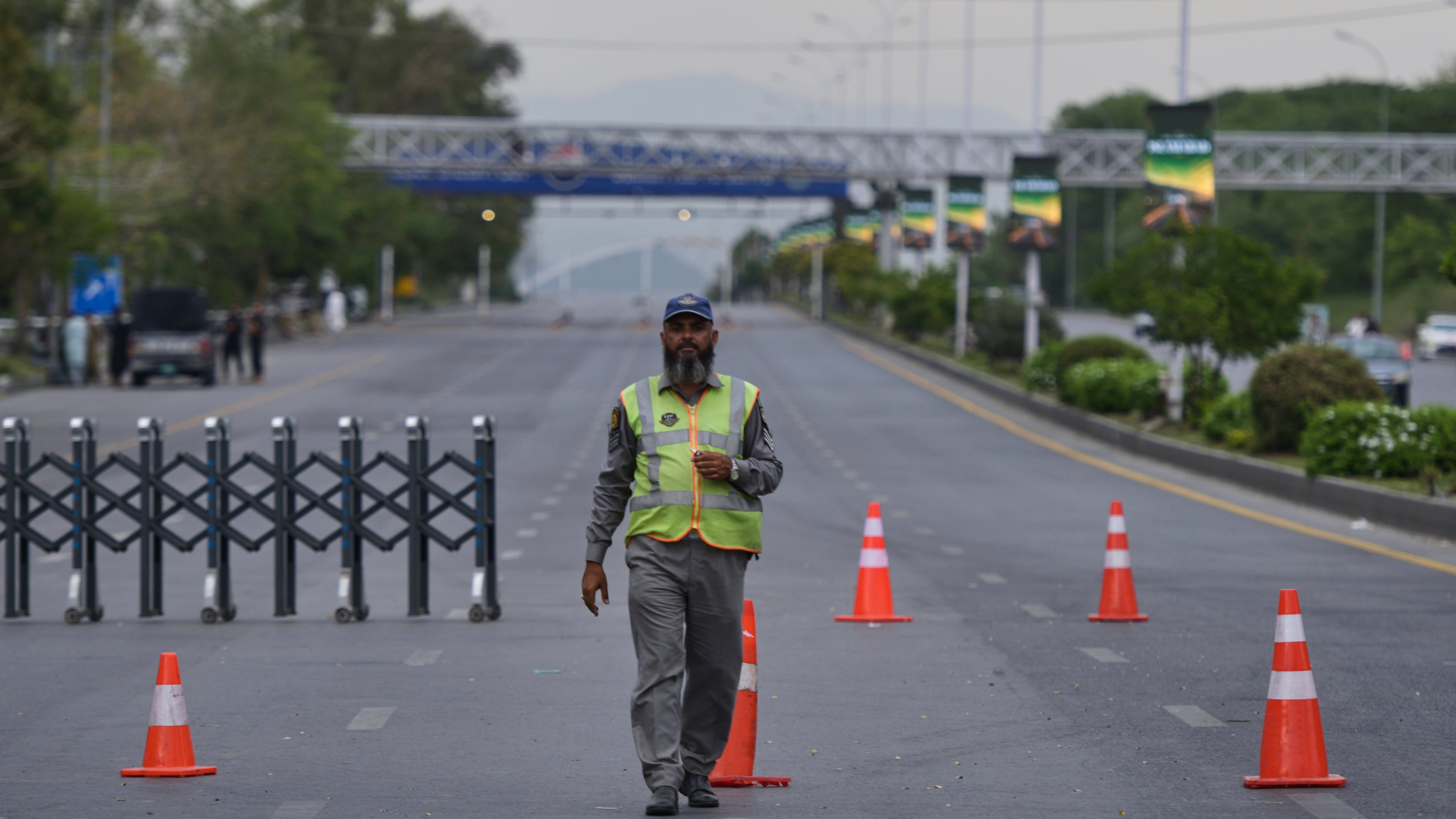 A police officer stands to divert traffic on a road barricaded by authorities due to security arrangements for possible second round of talks between the U.S. and Iran, in Islamabad, Pakistan, Friday, April 24, 2026. (AP Photo/M.A. Sheikh)