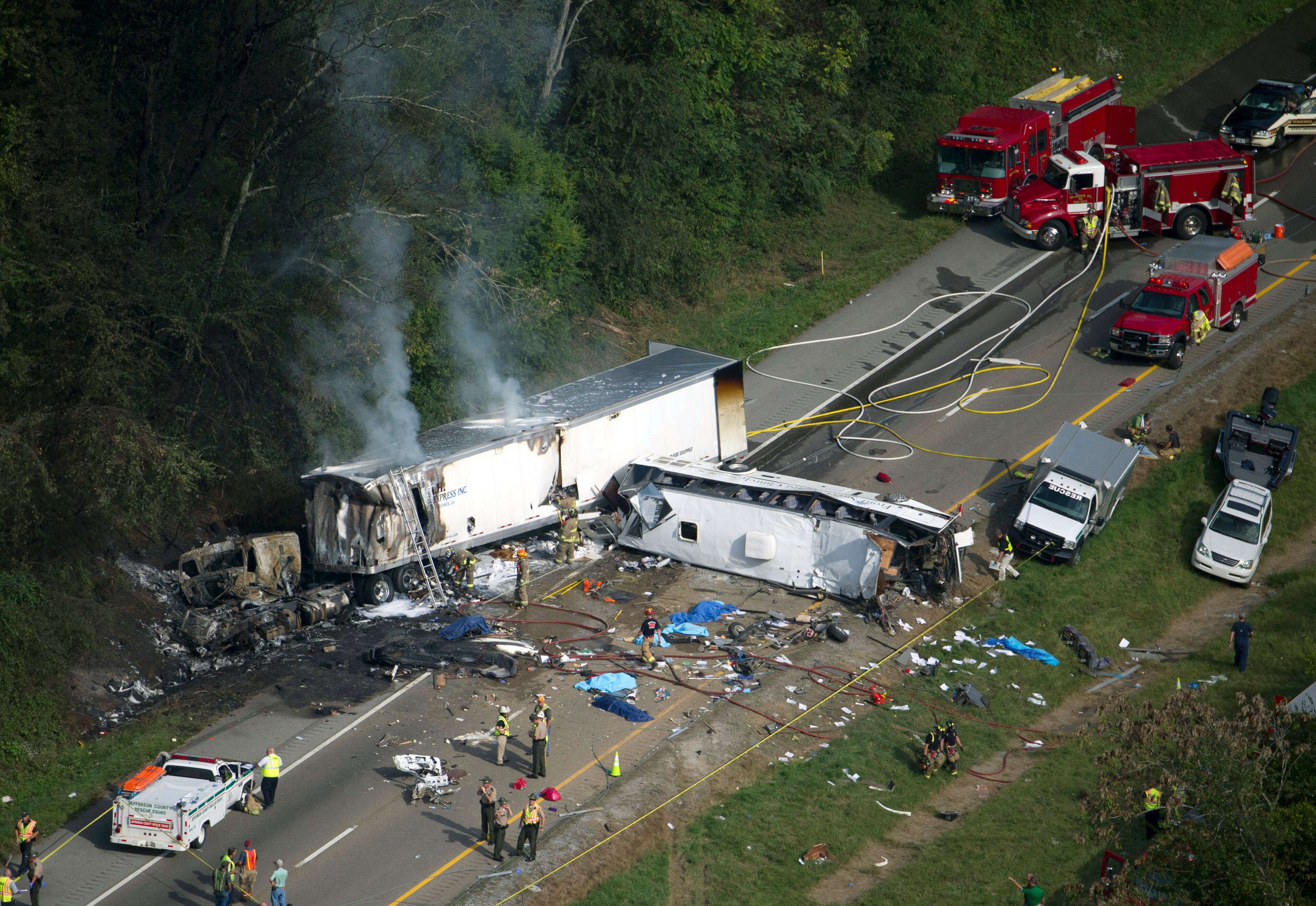 In this aerial photo, emergency workers respond to a crash involving a passenger bus, a tractor-trailer and an SUV near Dandridge, Tenn., on Wednesday, Oct. 2, 2013. Authorities said the bus, carrying members of a North Carolina church group, veered across the highway median and crashed into the other vehicles in a fiery wreck that killed several people. (AP Photo/The Knoxville News Sentinel, Paul Efird)