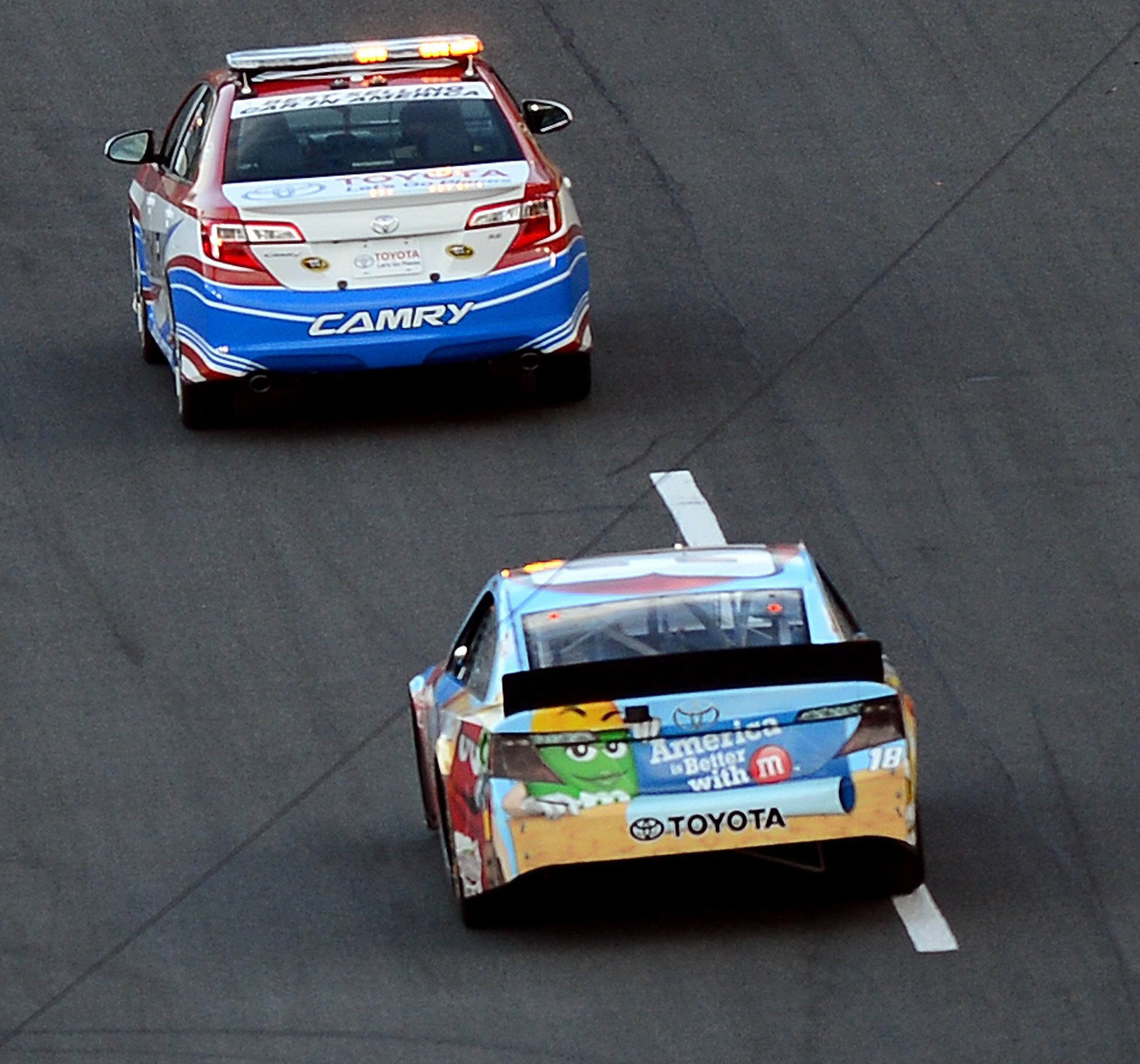 NASCAR Sprint Cup Series driver Kyle Busch (18) drives under a portion of the television CamCat overhead camera systems rope during the Coca Cola 600 at Charlotte Motor Speedway on Sunday, May 26, 2013, in Concord, North Carolina. A report provided by the speedway stated that 10 fans were injured when a nylon rope fell over the grandstands in Turn 4 on lap 121 of the race. Seven fans were treated for minor cuts and scrapes at on-site care centers and released. Three people were transported to an area hospital for further evaluation. The rope was a guide for the network television CamCat overhead camera system. (Jeff Siner/Charlotte Observer/MCT)
