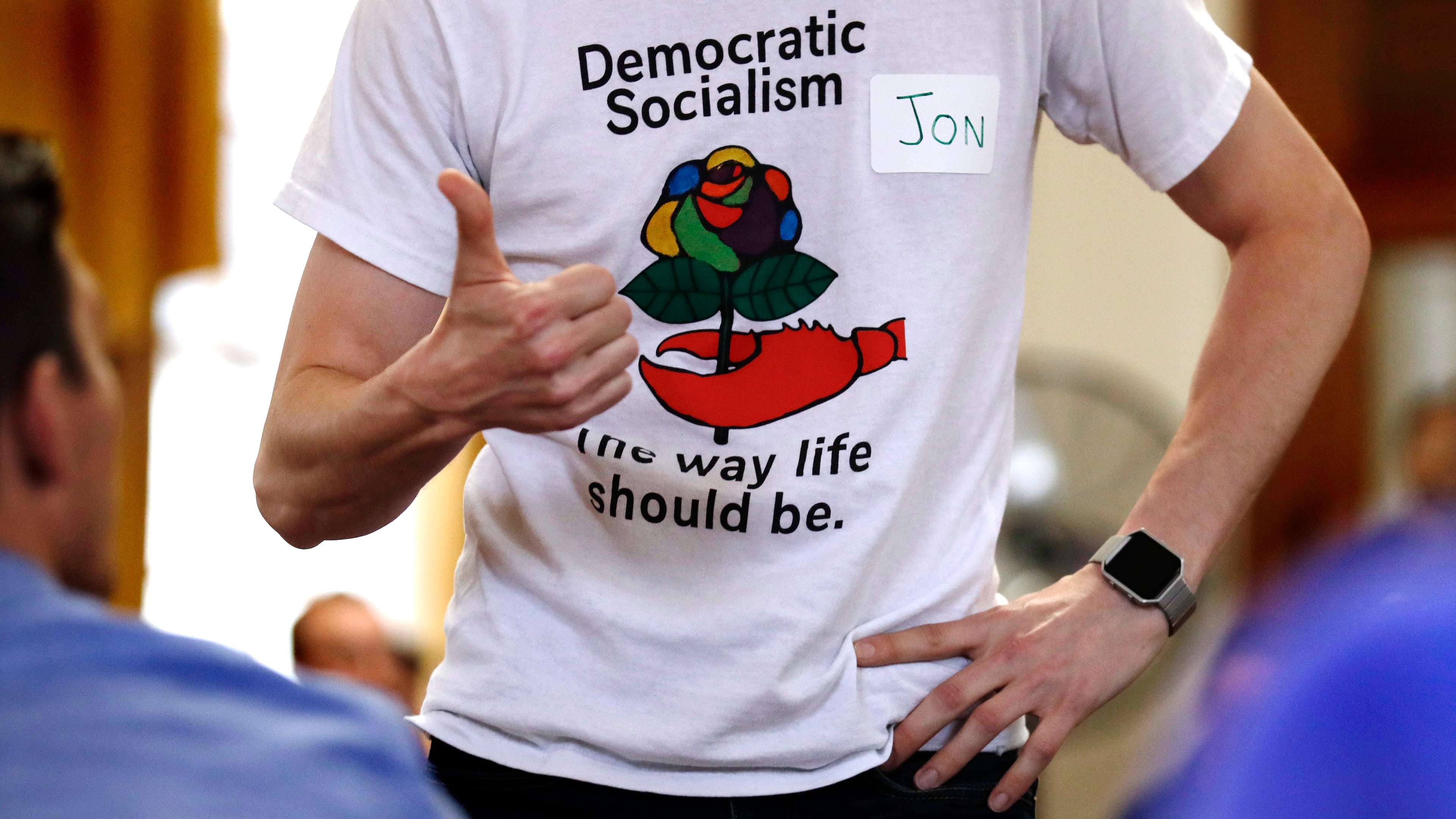 FILE - Jon Torsch wears a t-shirt promoting democratic socialism during a gathering of the Southern Maine Democratic Socialists of America at City Hall in Portland, Maine, July 16, 2018. (AP Photo/Charles Krupa)