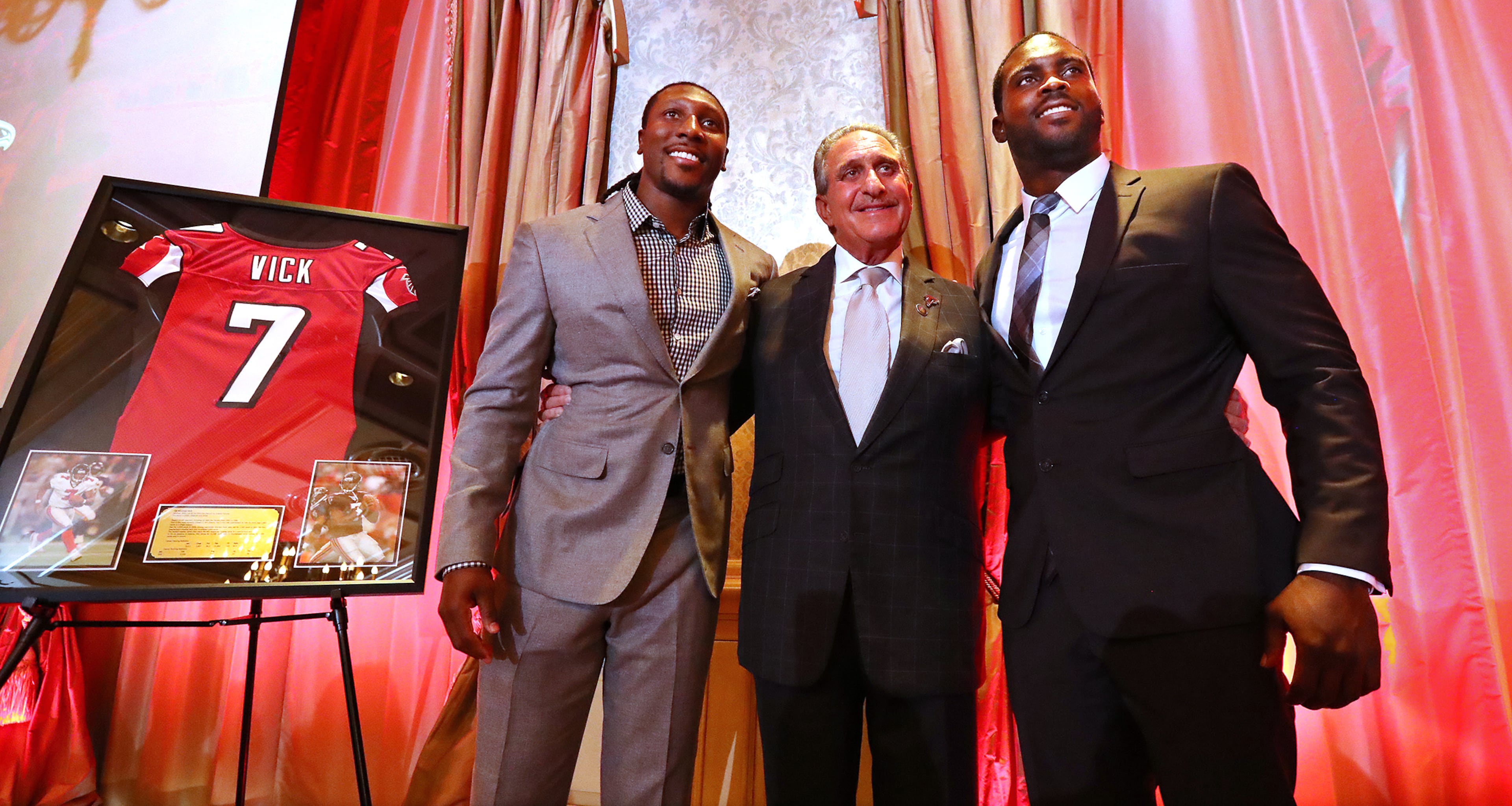 Falcons owner Arthur Blank honors former Falcons quarterback Michael Vick (right) and wide receiver Roddy White as they officially retire from the NFL Monday.