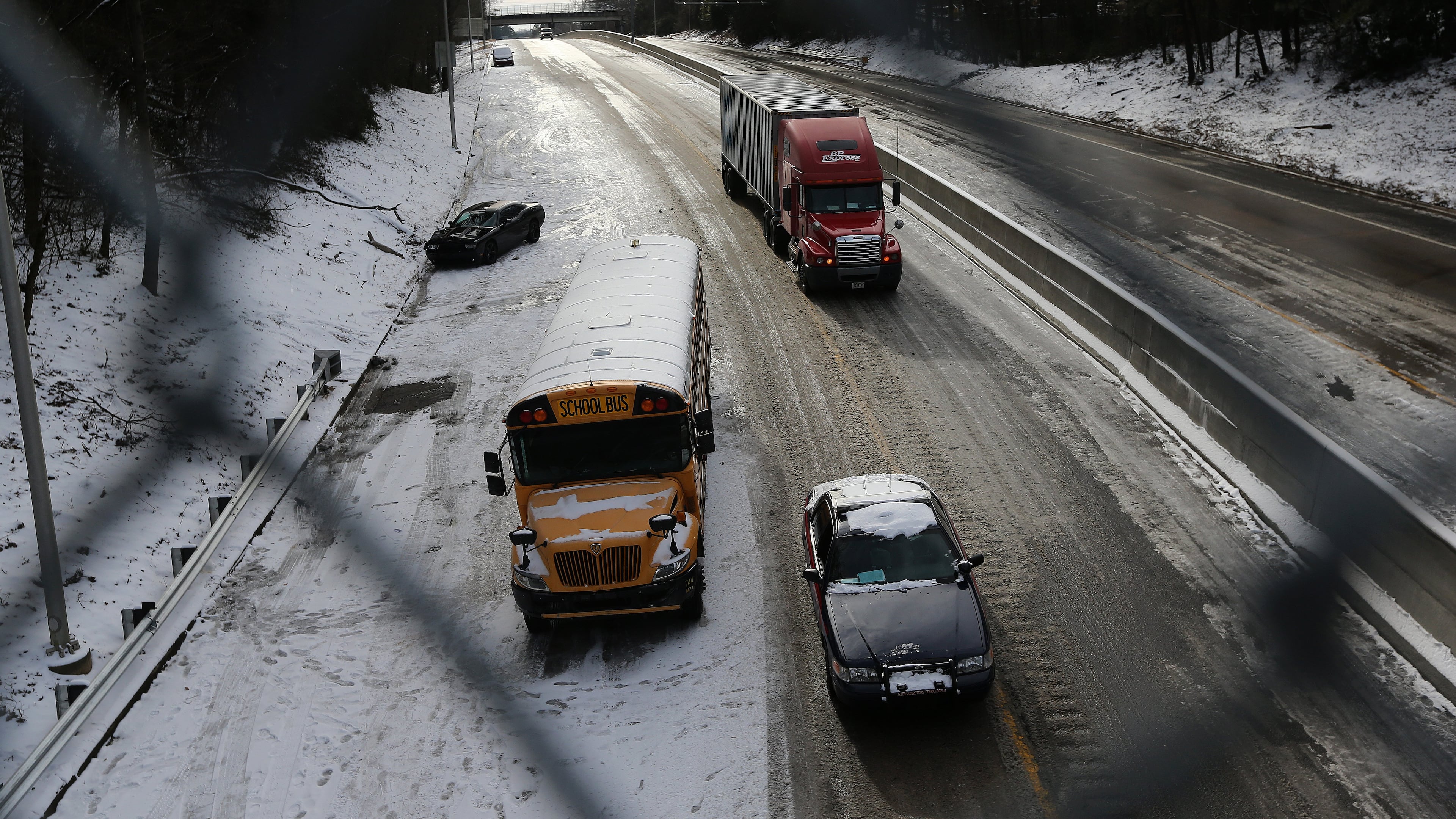 Remember this in 2014? A car police car and a tractor trailer drive past an abandon car and school buss on 166 in East Point on Wednesday afternoon January 29, 2014. BEN GRAY / BGRAY@AJC.COM
