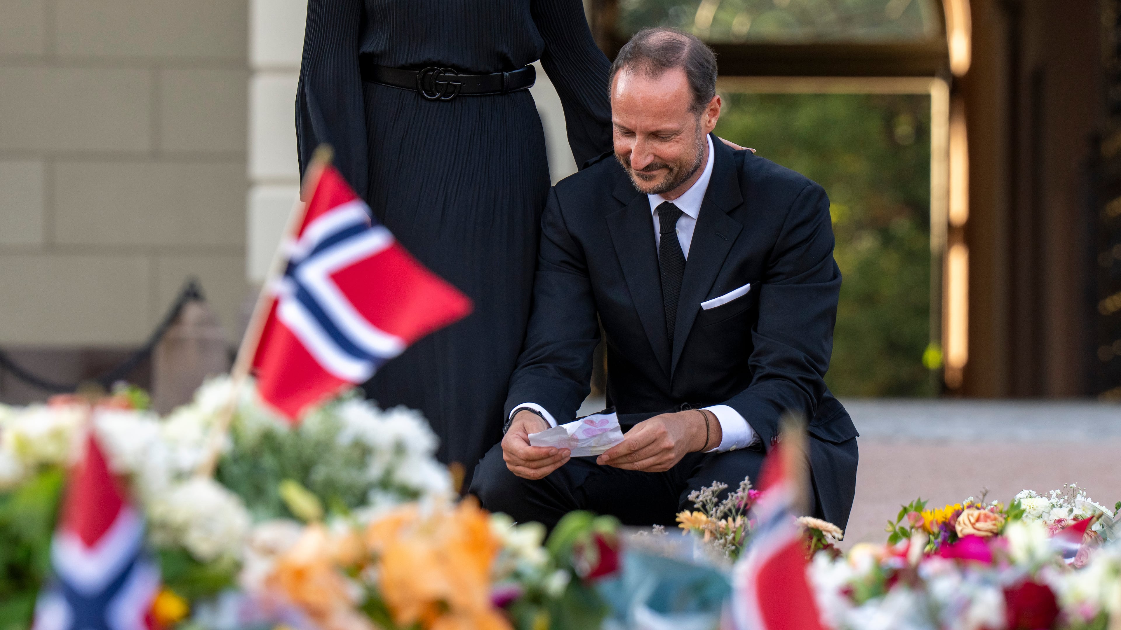 Norway's King Haakon reads greetings, that mourners have laid down in front of the Palace four days after the death of King Harald V., in Oslo Monday, Aug. 31, 2026. (Javad Parsa/NTB Scanpix via AP)