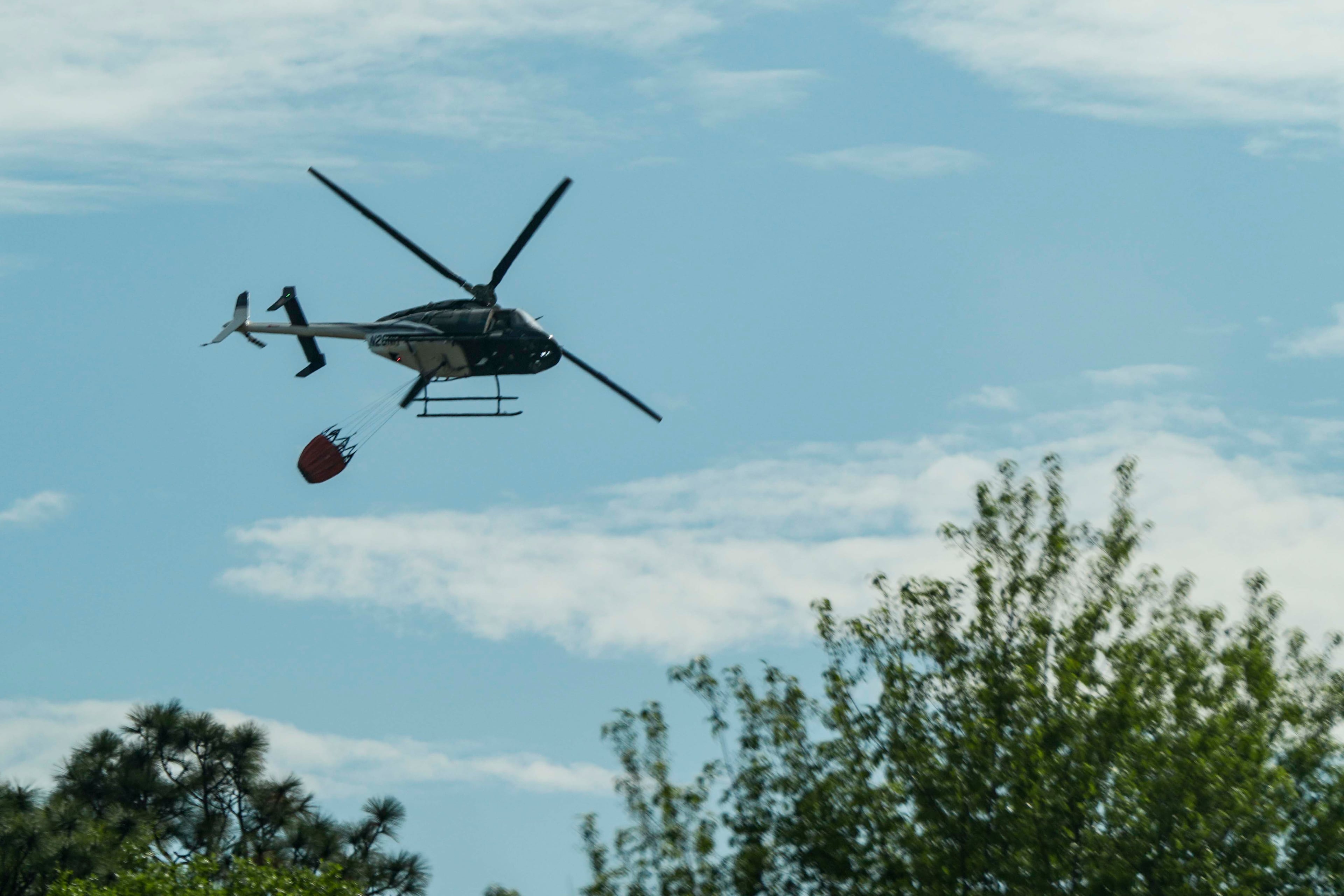 A fire helicopter prepares to drop water on the Pineland Road fire in Clinch County. (Mike Stewart/AP)