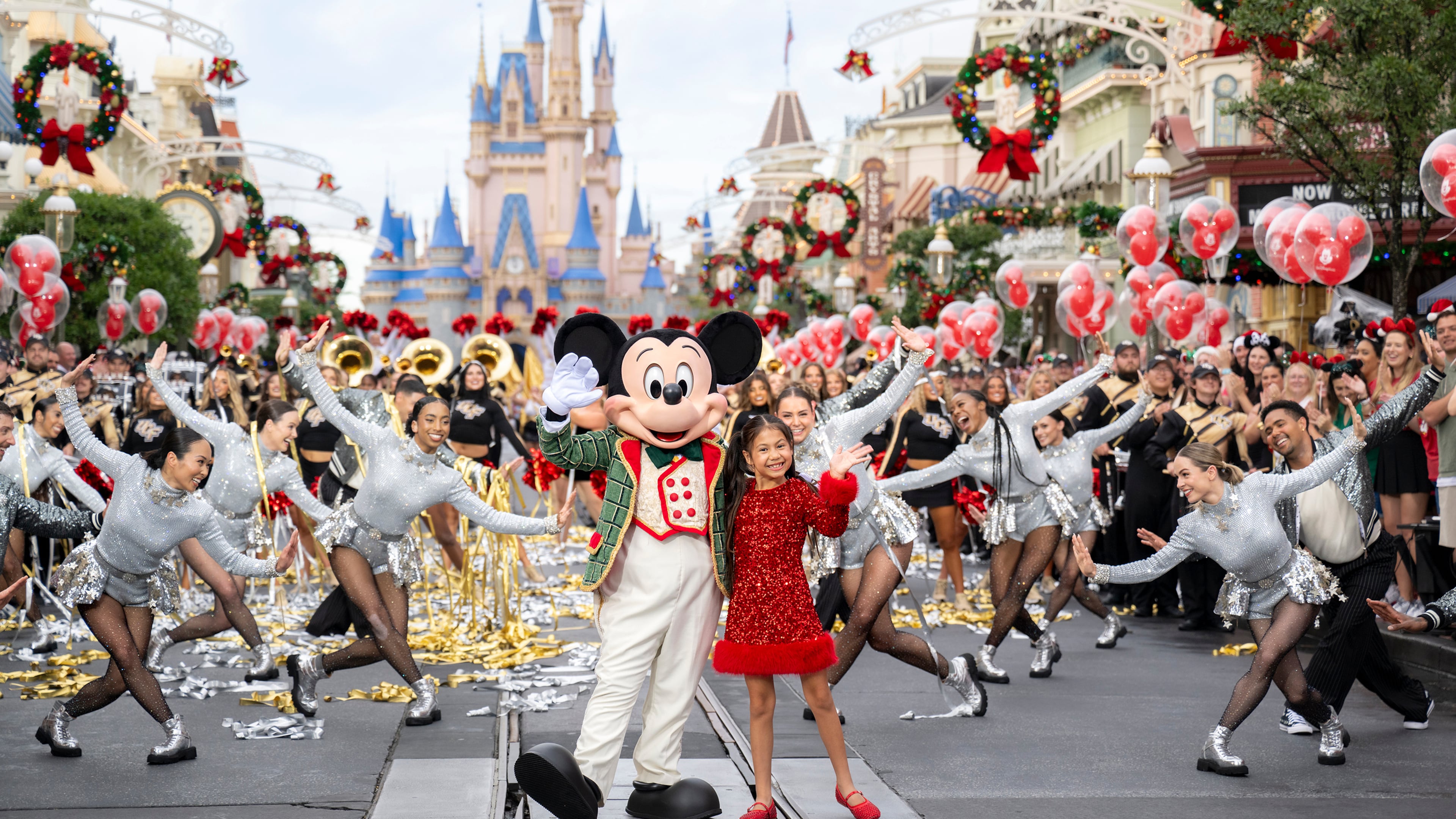 This image released by Disney shows Mickey Mouse and Maia Kealoha from the 40th Anniversary Disney Parks Magical Christmas Day Parade in Orlando, Fla. (Kenslie McGuire/Disney via AP)