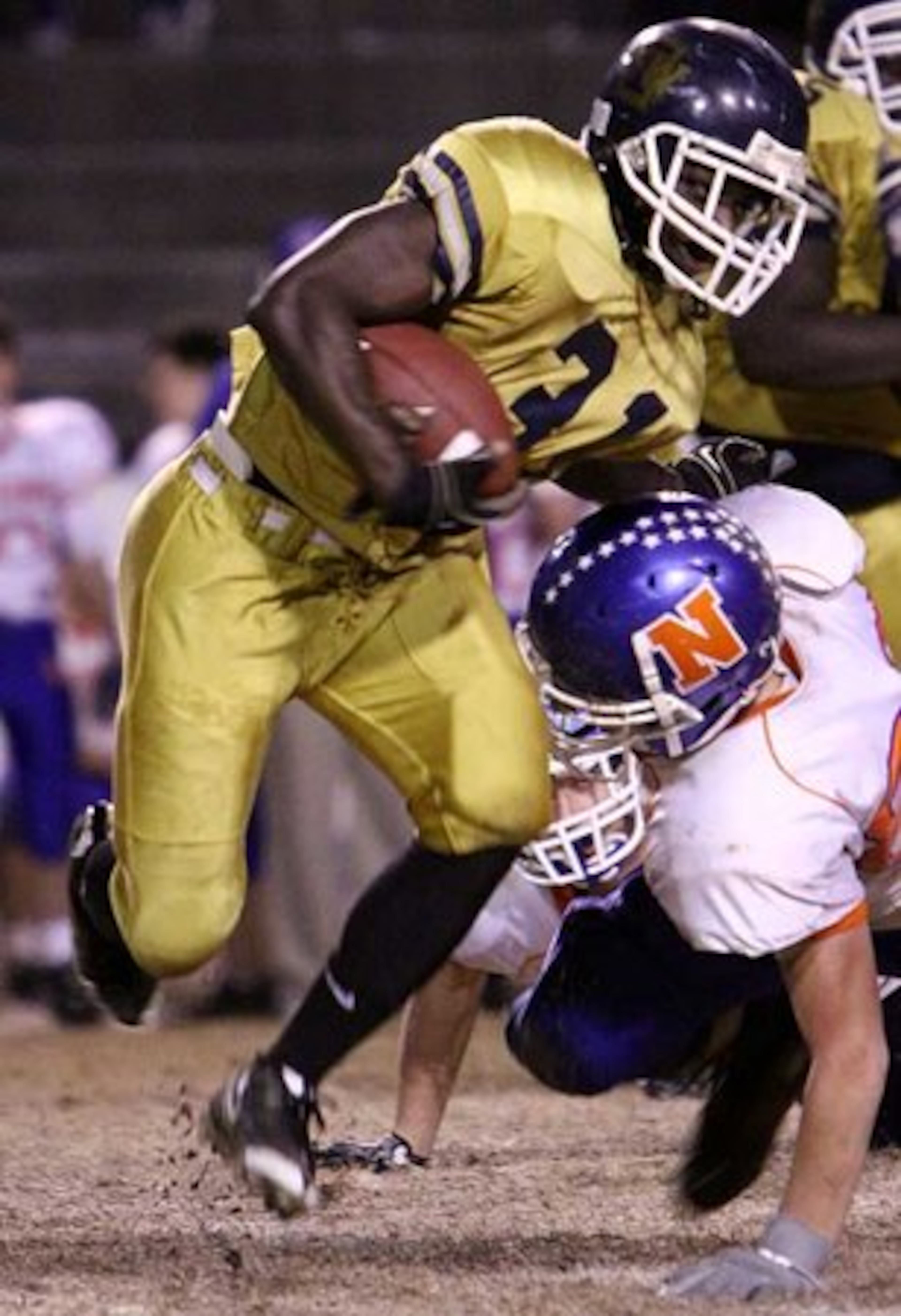 Isaac Bee (left), running back for Southwest DeKalb, pushes through the Northwest Whitfield defense as he eludes a would-be Bruins tackle to make a short gain.